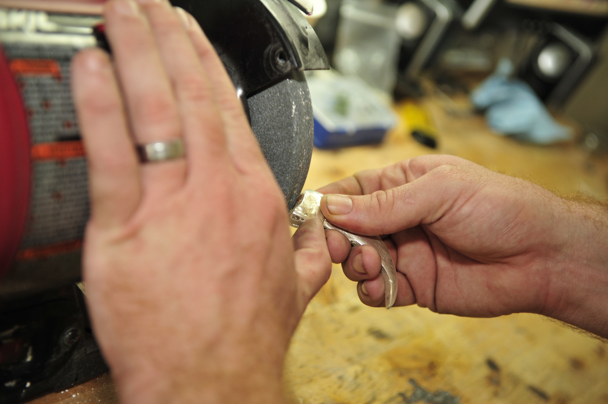Staff Sgt. James Ebbs, 6th Communications Squadron network infrastructure supervisor, sands one of the claws to smooth away any imperfections in the silver. The tops of the two claws were sealed with copper, which marked where the ashes were located. (U.S. Air Force photo by Airman 1st Class Sarah Breer/released)