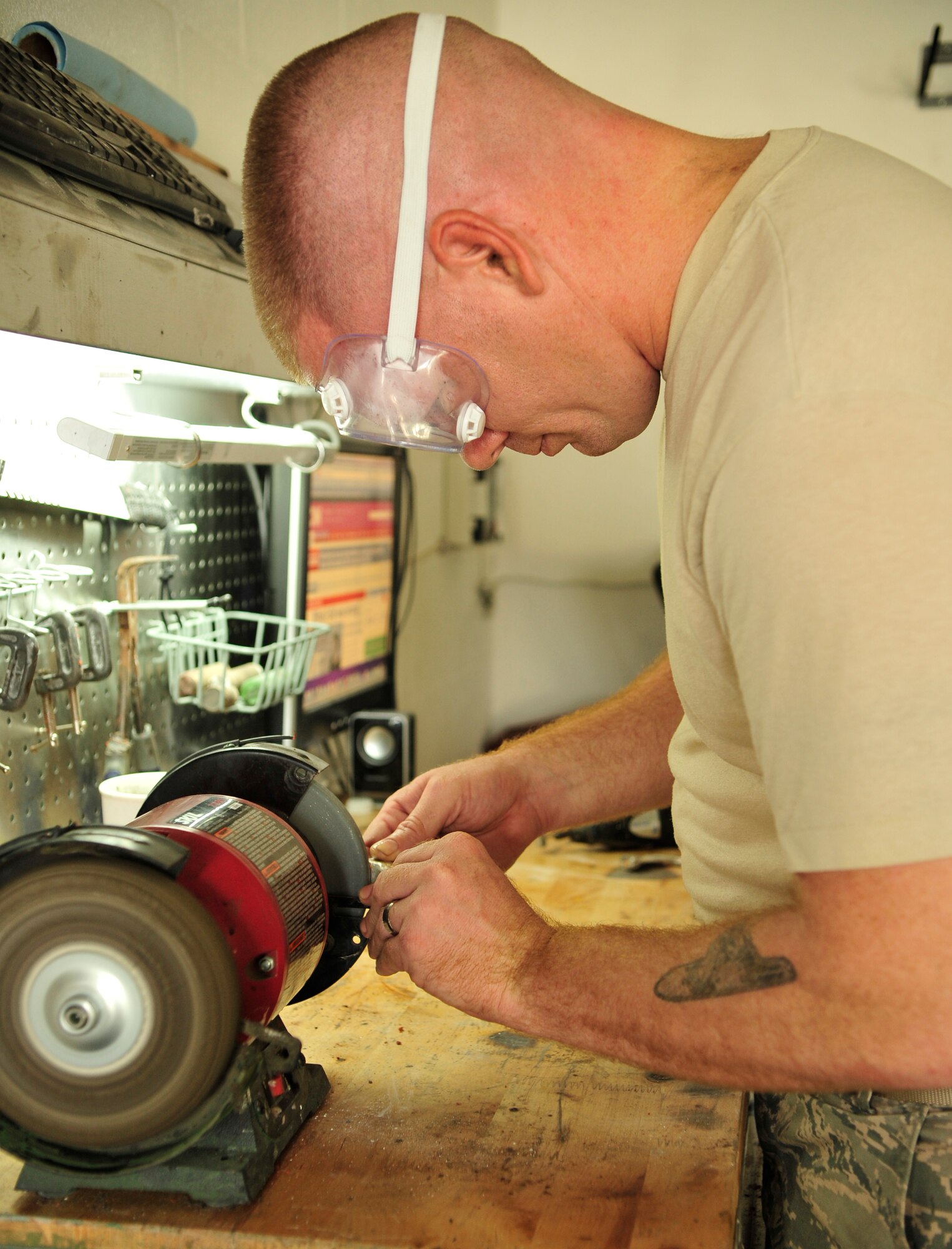 Staff Sgt. James Ebbs, 6th Communications Squadron network infrastructure supervisor, sands one of the claws to smooth away any imperfections. Ebbs worked on the claws for about two weeks before they were ready to ship to the customer. (U.S. Air Force photo by Airman 1st Class Sarah Breer/released)