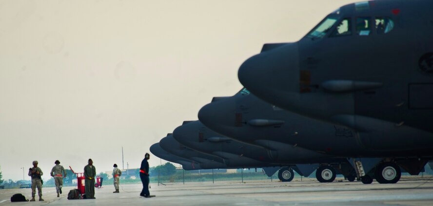 Airmen from the 5th Security Forces Squadron and Airmen from the 5th Aircraft Maintenance Squadron perform their perspective duties during a minimum-interval takeoff at Minot Air Force Base, N.D., Aug. 15, 2013. A MITO take-off uses starter cartridges filled with gun powder to quickly fire up the B-52’s engines. (U.S. Air Force photo/Senior Airman Brittany Y. Auld)