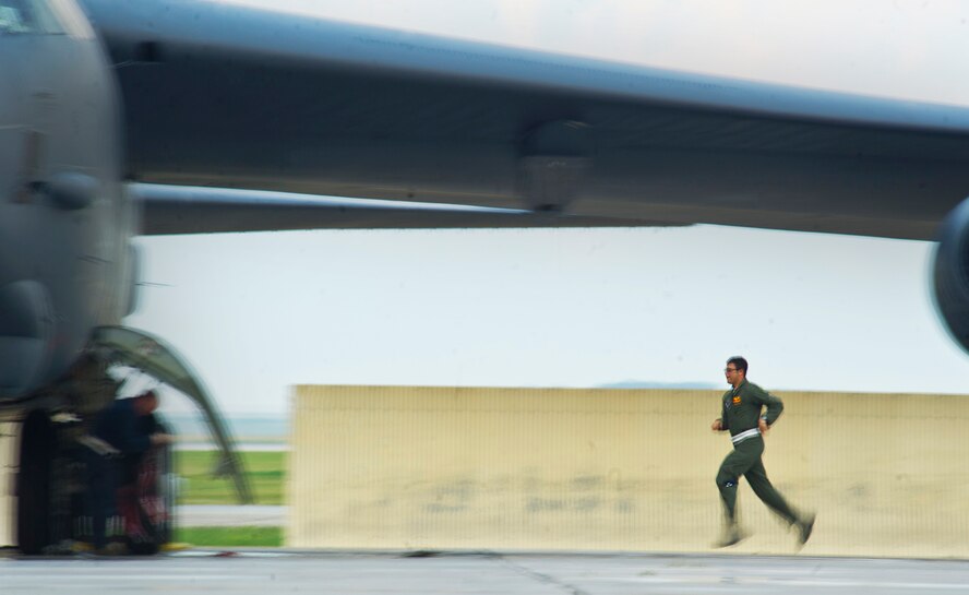 An Aircrew member runs to the B-52H Stratofortress to prepare for takeoff during a minimum-interval takeoff at Minot Air Force Base, N.D., Aug. 15, 2013. In a conventional conflict, the B-52 can perform strategic attack, close-air support, air interdiction, offensive counter-air and maritime operations. (U.S. Air Force photo/Senior Airman Brittany Y. Auld)