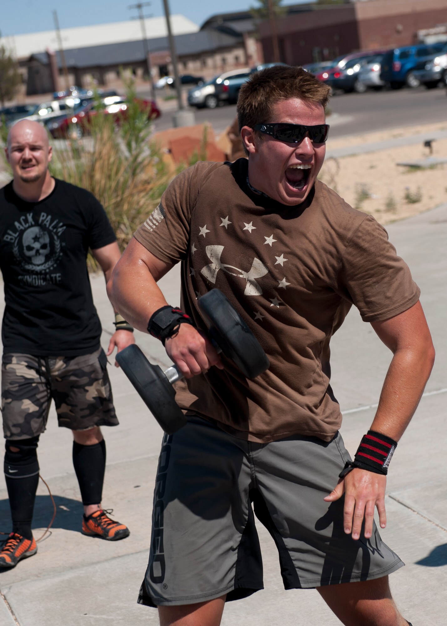 An Airman lifts a weight above his head as a part of the “Fittest Wingman challenge” at Holloman Air Force Base, N.M., Aug. 16. The Fittest Wingman Challenge was part of Comprehensive Airman Fitness Day which encouraged a total fitness approach to well-being. This quarters CAF day was focused on physical fitness, members of Team Holloman participated in a wing run, followed by various sporting events.  Participants learned the importance of physical activity and comradery. (U.S. Air Force photo by Airman 1st Class Daniel E. Liddicoet/Released)