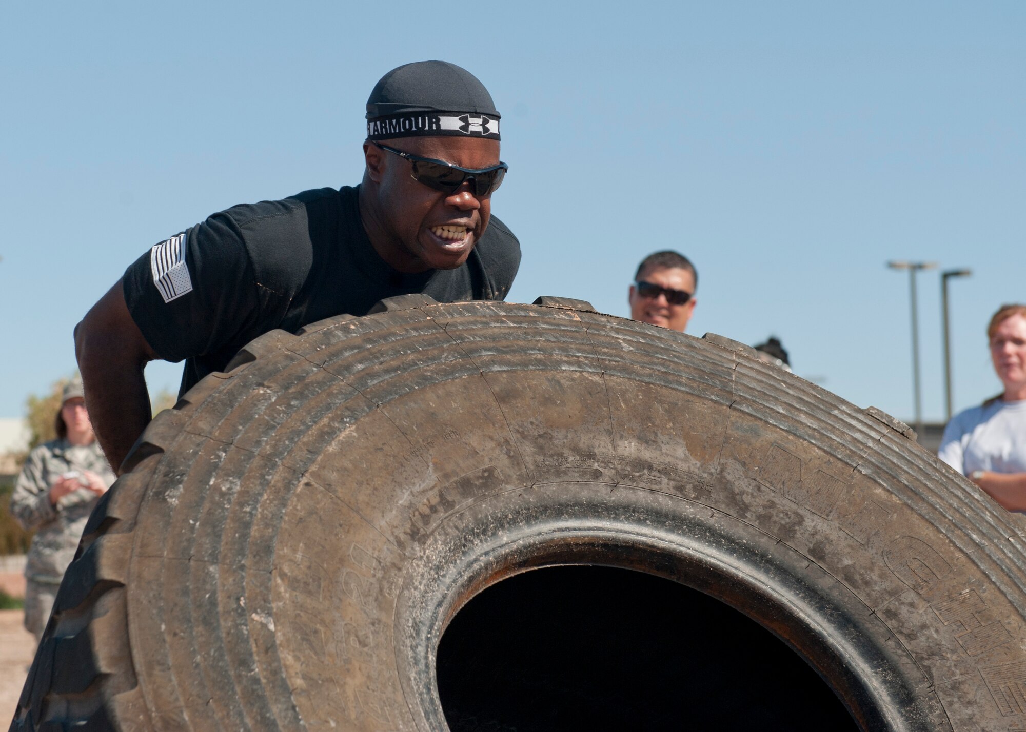 An Airman flips a tire as a part of the “Fittest Wingman Challenge” at Holloman Air Force Base, N.M., Aug. 16. The Fittest Wingman Challenge was part of Comprehensive Airman Fitness Day which encouraged a total fitness approach to well-being. This quarters CAF day was focused on physical fitness, members of Team Holloman participated in a wing run, followed by various sporting events.  Participants learned the importance of physical activity and comradery. (U.S. Air Force photo by Airman 1st Class Daniel E. Liddicoet/Released)