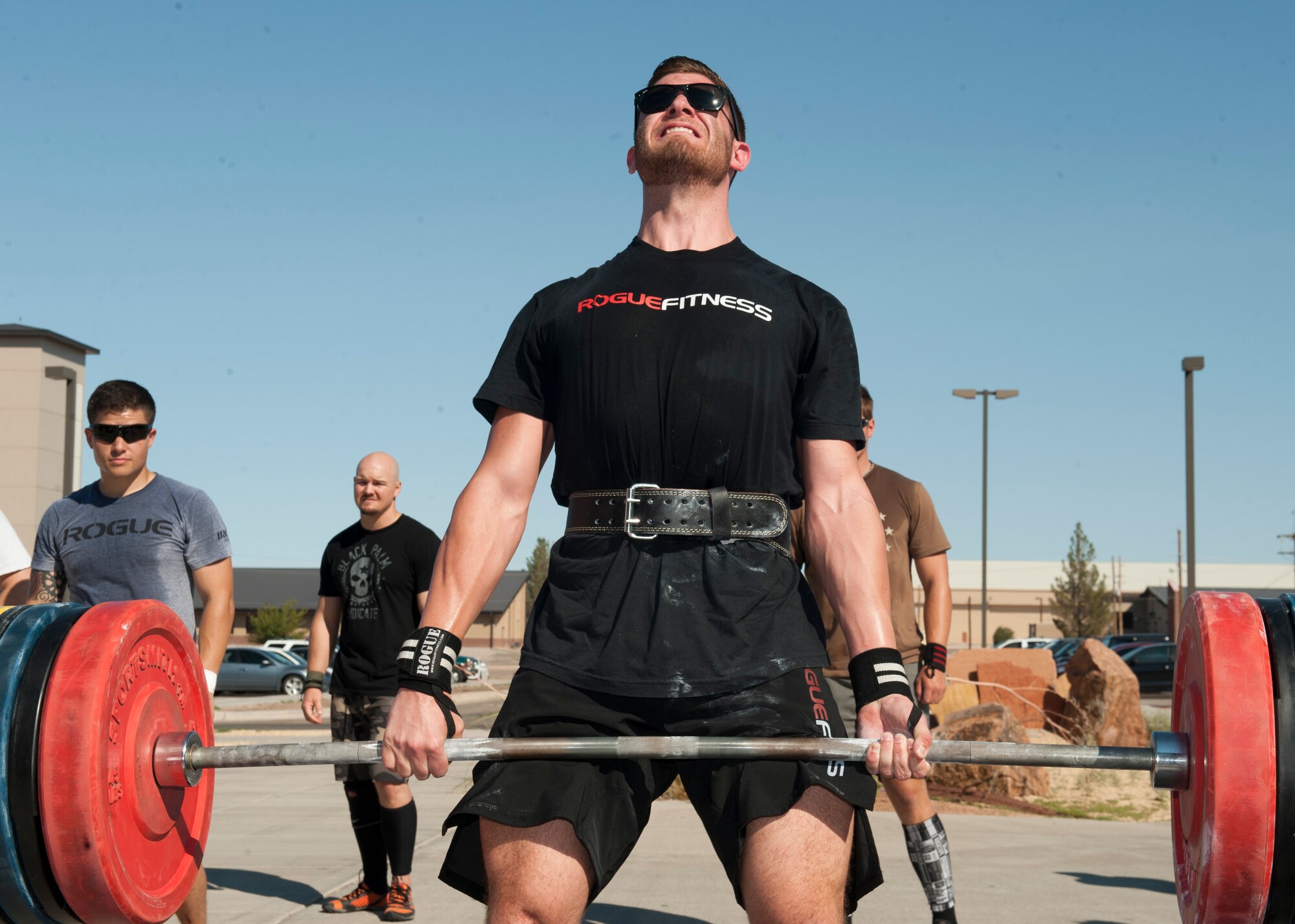 A member of Team Holloman performs a dead lift as a part of the “Fittest Wingman Challenge” at Holloman Air Force Base, N.M., Aug. 16. The Fittest Wingman Challenge was part of Comprehensive Airman Fitness Day which encouraged a total fitness approach to well-being. This quarters CAF day was focused on physical fitness, members of Team Holloman participated in a wing run, followed by various sporting events.  Participants learned the importance of physical activity and comradery. (U.S. Air Force photo by Airman 1st Class Daniel E. Liddicoet/Released)