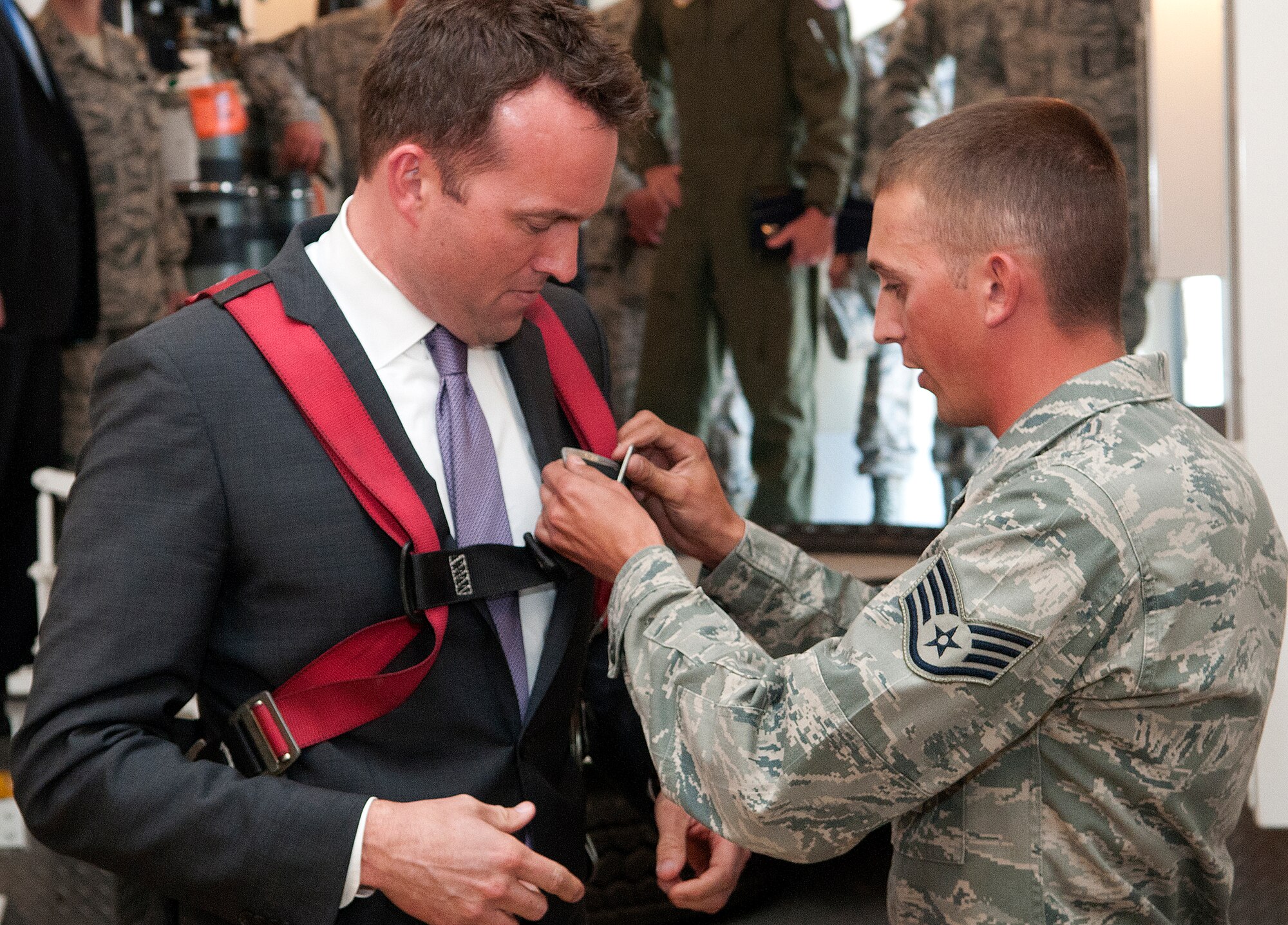 Acting Secretary of the Air Force Eric Fanning, is helped into a safety harness by Staff Sgt. Nicholas Kolja, 90th Maintenance Operations Squadron, inside a payload transport during a visit to F.E. Warren Air Force Base, Wyo., Aug. 15, 2013. Fanning put on the harness so to take a closer look at a training re-entry system used to train 90th Maintenance Group personnel in missile maintenance procedures. (U.S. Air Force photo by R.J. Oriez)