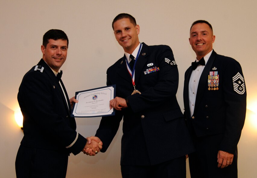 Senior Airman Adrian Hernandez, 2nd Aircraft Maintenance Squadron, receives an Airman Leadership School graduation certificate from Col. Andrew Gebara, 2nd Bomb Wing commander, on Barksdale Air Force Base, La., Aug. 15, 2013. (U.S. Air Force photo)
