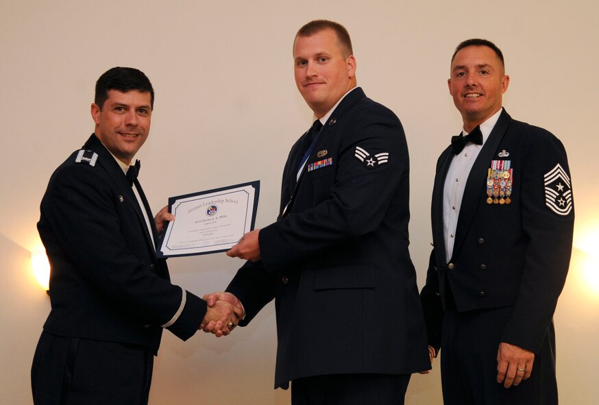 Senior Airman Zachary Wills, 2nd Aircraft Maintenance Squadron, receives an Airman Leadership School graduation certificate from Col. Andrew Gebara, 2nd Bomb Wing commander, on Barksdale Air Force Base, La., Aug. 15, 2013. (U.S. Air Force photo)