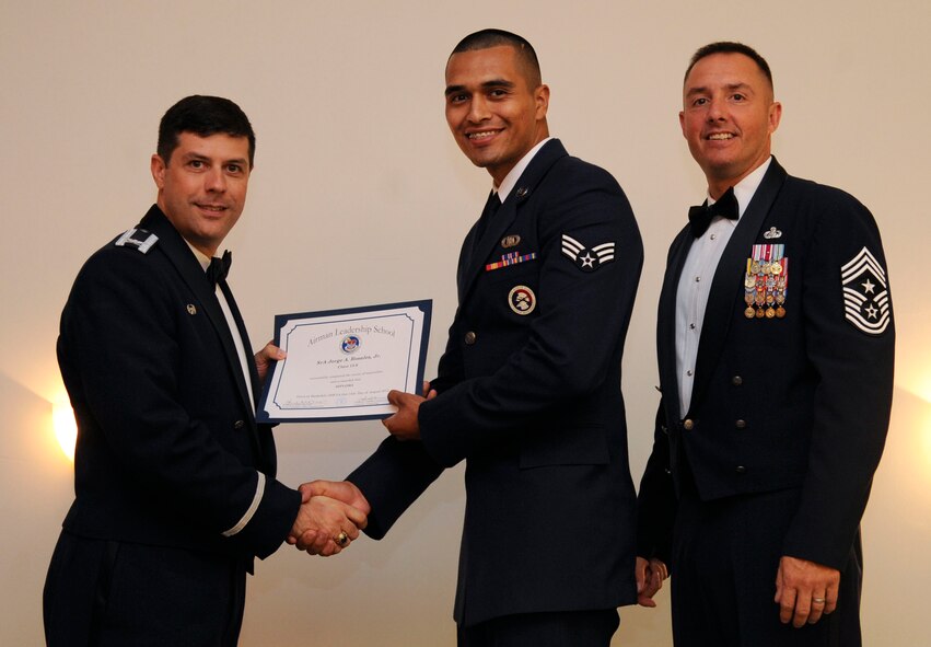 Senior Airman Jorge Rosales, 931st Aircraft Maintenance Squadron, receives an Airman Leadership School graduation certificate from Col. Andrew Gebara, 2nd Bomb Wing commander, on Barksdale Air Force Base, La., Aug. 15, 2013. (U.S. Air Force photo)
