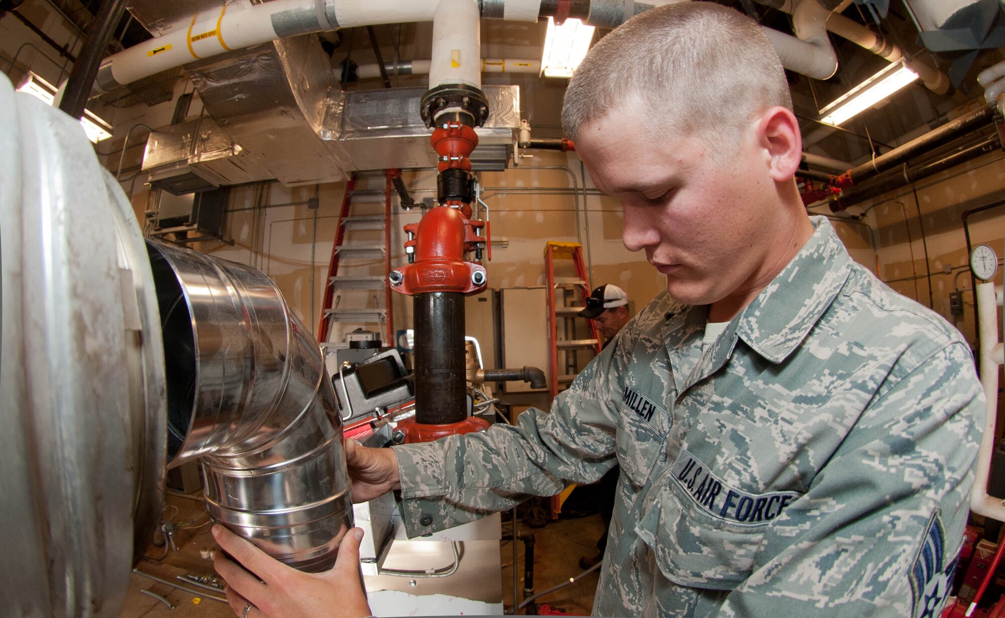 Senior Airman David McMillen, 28th Civil Engineer Squadron heating, ventilation and air conditioning technician, installs an exhaust stack into a new boiler system in the base Exchange at Ellsworth Air Force Base, S.D., Aug. 15, 2013. McMillen is responsible for installing and maintaining heating, ventilation and air conditioning systems on all base facilities. (U.S. Air Force photo by Airman 1st Class Zachary Hada/Released)
