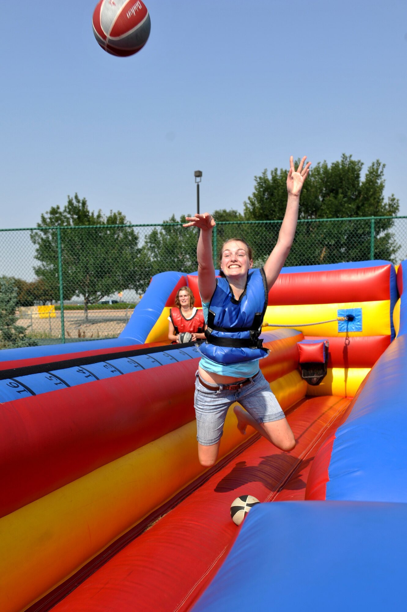 A Team Buckley spouse attempts a basket while playing on an inflatable bungee game at Fun Fest Aug. 16, 2013, at the softball fields on Buckley Air Force Base, Colo. The 460th Space Wing celebrated its ninth birthday with Fun Fest, a day filled with sport competitions and a community fair. (U.S. Air Force photo by Airman 1st Class Riley Johnson/Released)