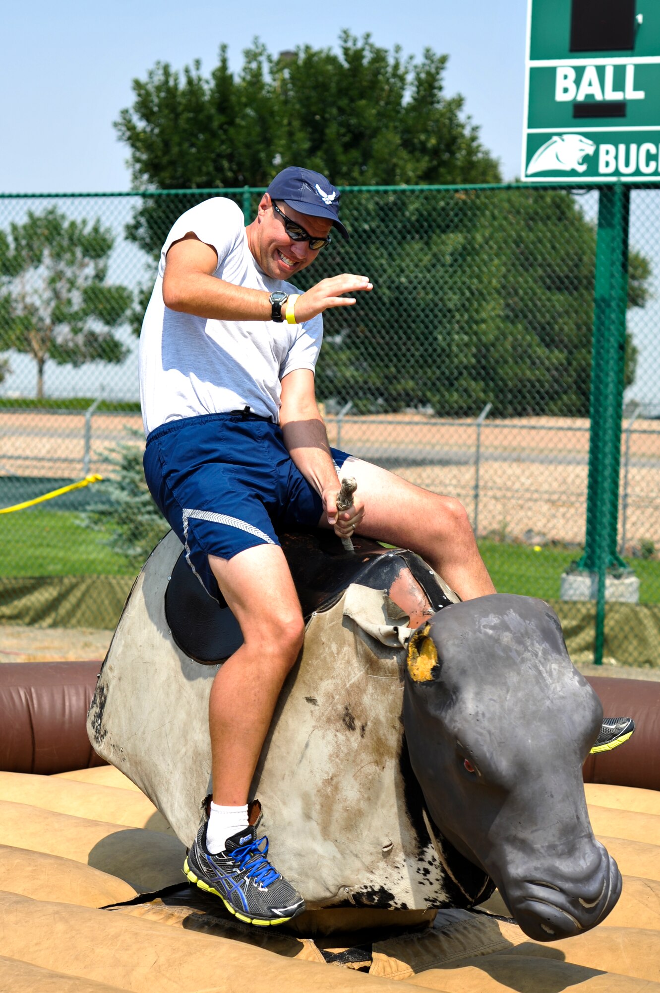 Lt. Col. Derek Bright, 460th Operations Group, channels his inner cowboy while riding a mechanical bull during Fun Fest Aug. 16, 2013, at the softball fields on Buckley Air Force Base, Colo. The 460th Space Wing celebrated its ninth birthday with Fun Fest, a day filled with sport competitions and a community fair. (U.S. Air Force photo by Airman 1st Class Riley Johnson/Released)