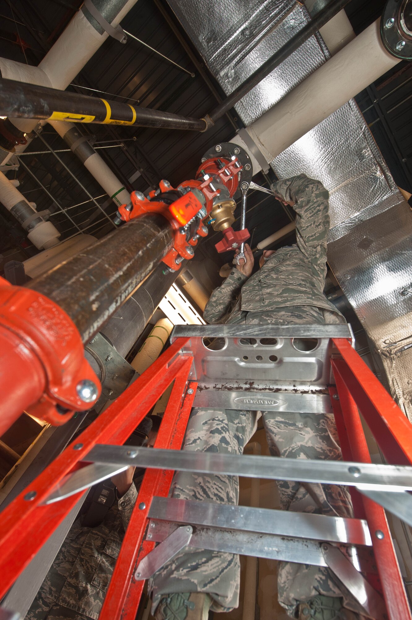 Senior Airman David McMillen, 28th Civil Engineer Squadron heating, ventilation and air conditioning technician, connects water pipes during the installation of a new boiler system in the base Exchange at Ellsworth Air Force Base, S.D., Aug. 15, 2013. The 28th CES HVAC Airmen maintain, install and repair refrigeration, ventalation and heating systems, saving the Air Force more than $75,000 per job. (U.S. Air Force photo by Airman 1st Class Zachary Hada/Released)