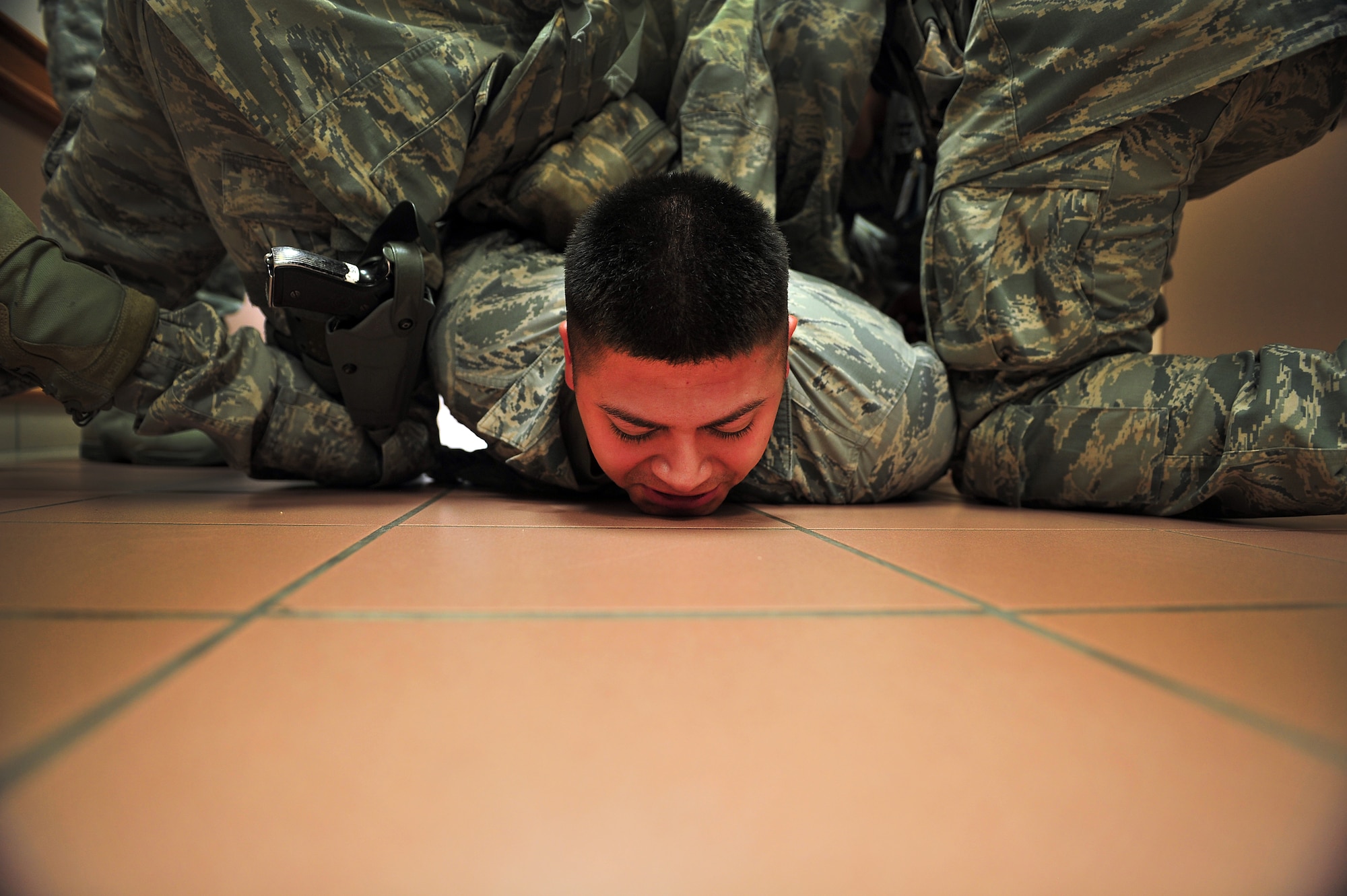 U.S. Air Force Senior Airman Agustine Cansino, 27th Special Operations Medical Operations Squadron, is subdued by 27th Special Operations Medical Group personnel during an exercise Aug. 16, 2013 at Cannon Air Force Base, N.M. The exercise gave the Cannon Fire Department, emergency medical personnel and Security Forces personnel a chance to fine-tune their skills in emergency response to an on base occurrence.  (U.S. Air Force photo/Tech. Sgt. Josef Cole)