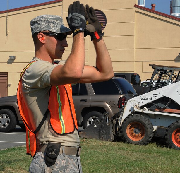 Airman 1st Class Cameron Kruell, 2nd Civil Engineer Squadron pavement and equipment section, guides a bobcat into place during road construction on Barksdale Air Force Base, La., Aug. 19, 2013. CE Airmen have the responsibility of maintaining and setting up Barksdale's infrastructure, ranging from roads and pavement, construction projects and Barksdale's flightline. (U.S. Air Force photo/Senior Airman Sean Martin)

