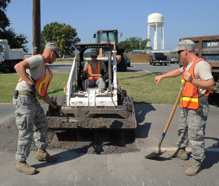 Airmen from the 2nd Civil Engineer Squadron pavement and equipment section repair a road on Barksdale Air Force Base, La., Aug. 19, 2013. CE Airmen use a variety of heavy equipment such as front-end loaders, bulldozers and backhoes to accomplish a number of tasks around the base. (U.S. Air Force photo/Senior Airman Sean Martin)