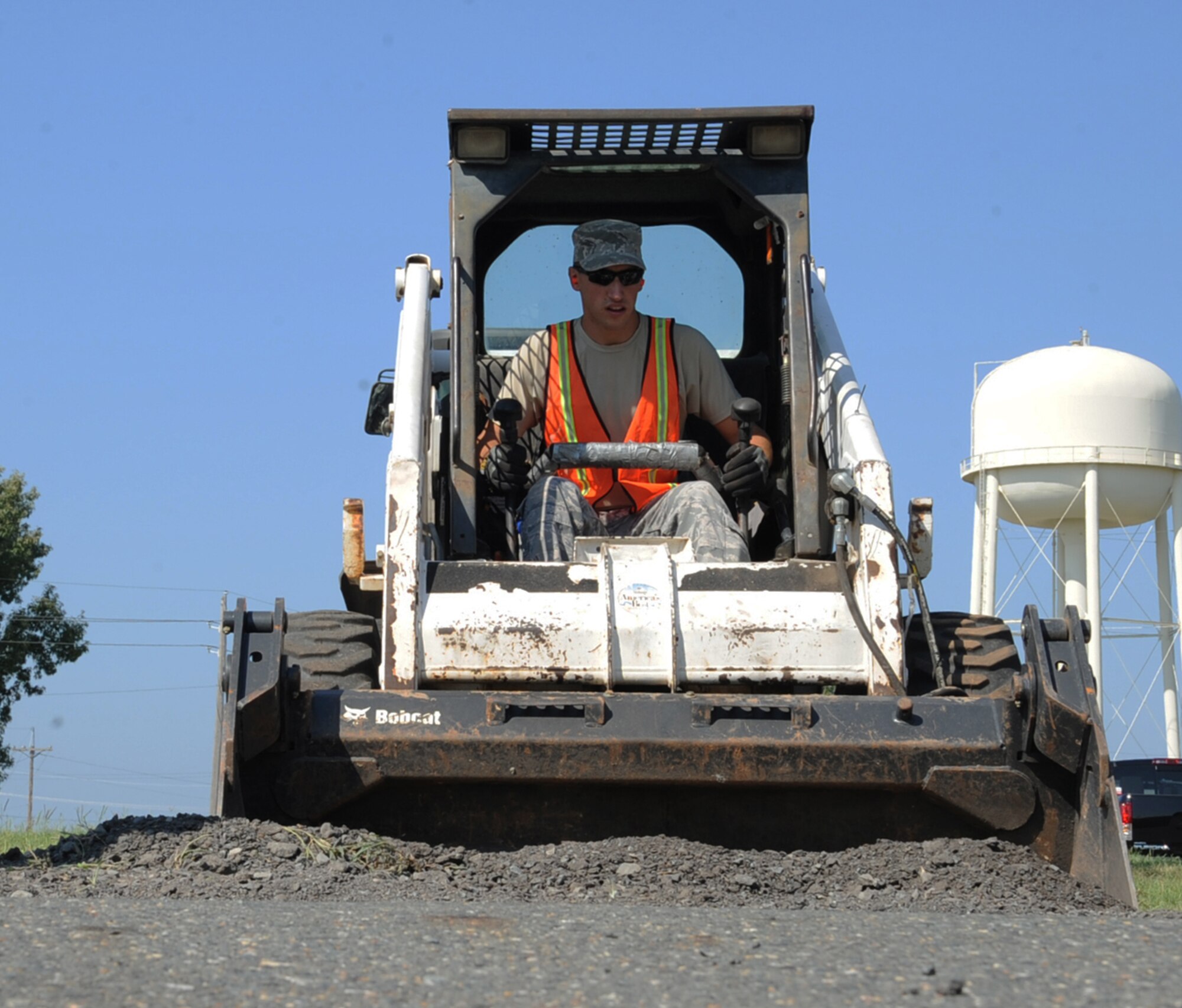 Airman 1st Class Cameron Kruell, 2nd Civil Engineer Squadron pavement and equipment section, picks up excess gravel on Barksdale Air Force Base, La., Aug. 19, 2013. The CE Airmen were repairing a depression in the road caused by previous construction work. (U.S. Air Force photo/Senior Airman Sean Martin)

