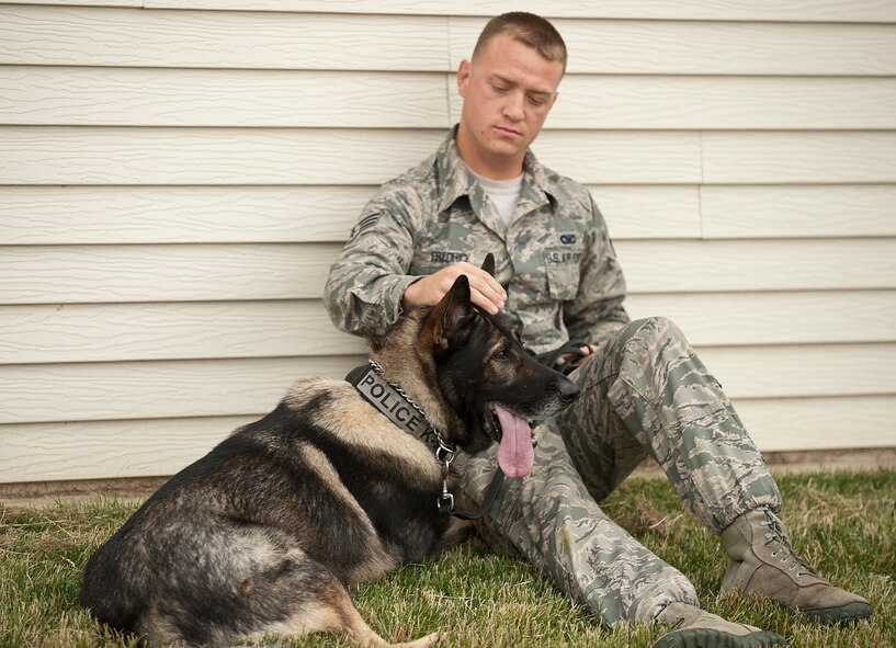 Senior Airman Zachary Fredrick, a military dog handler for the 5th Security Forces Squadron, rests with his dog Roko after performing in the K-9 competition held at the Minot Air Force Base, N.D., kennels on Aug.  14, 2013. Military working dogs and handlers from state law enforcement, as well as members from Grand Forks AFB, N.D., and Minot AFB’s 319th Security Forces Squadron competed in the course to showcase their skills, discipline and teamwork. (U.S. Air Force photo/Airman 1st Class Lauren Pitts)