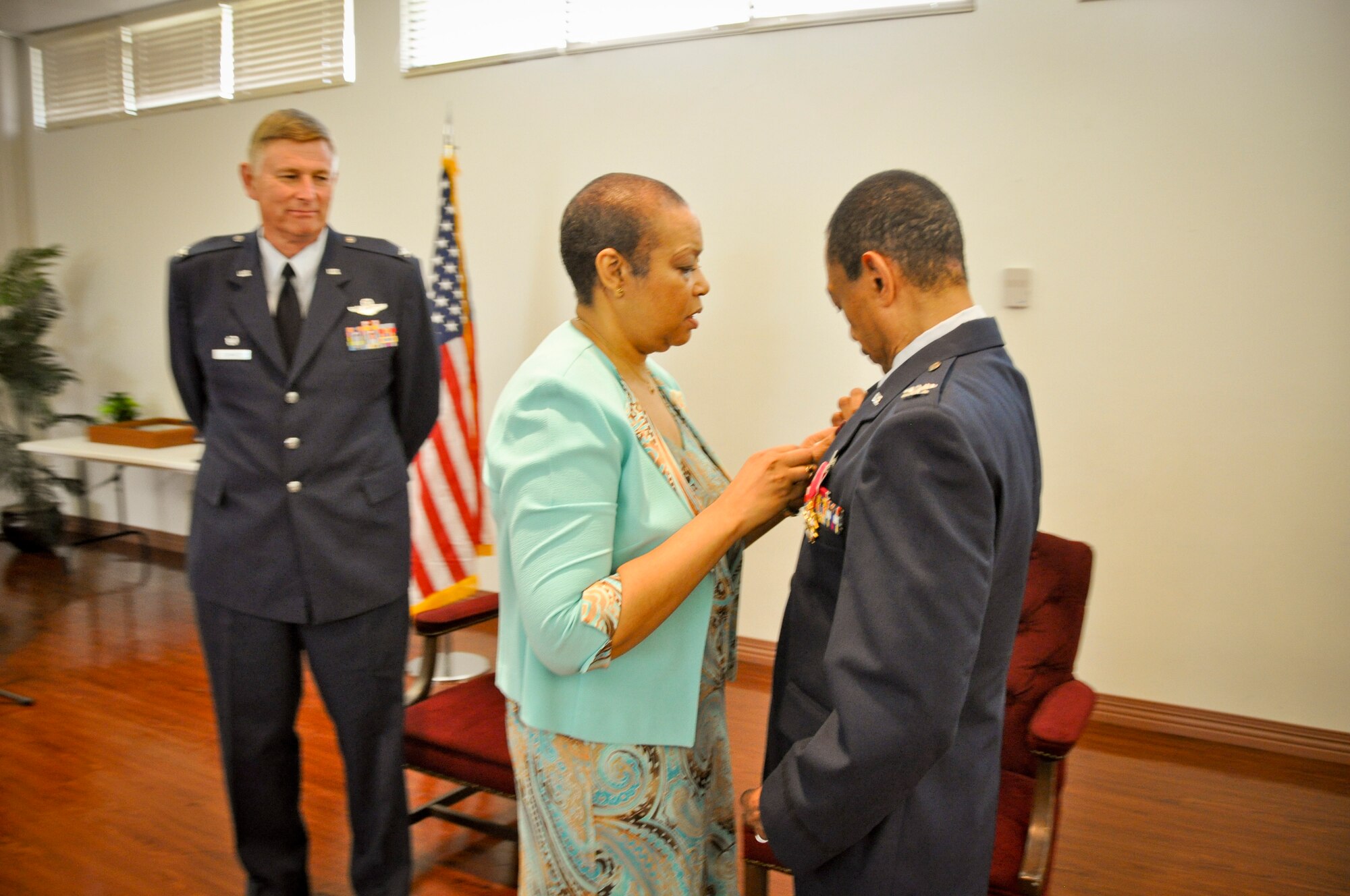 MACDILL AIR FORCE BASE, Fla. – Colonel Rodney Bryan, right, received his retirement pin from his wife during a ceremony here Aug. 3, 2013.  Bryan concluded a 38-year career in the Air Force as commander of the 927tH Mission Support Group and special advisor to the wing commander.  Standing in the background is Col. Doug Schwartz, commander of the 927th Air Refueling Wing. (Official U.S. Air Force photo/Tech. Sgt. Shawn Rhodes)