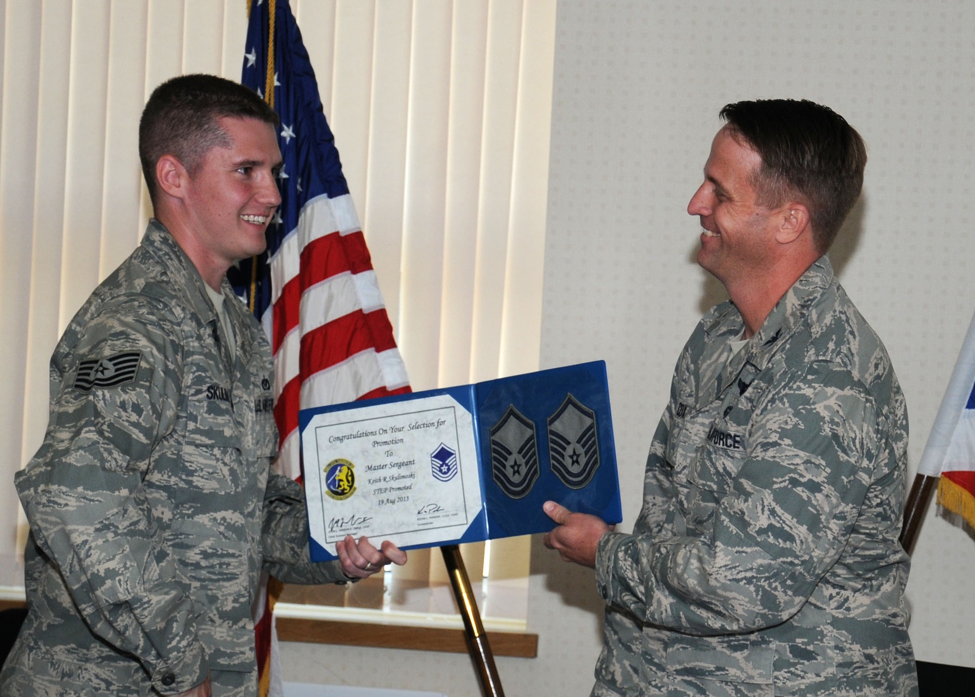 From right, U.S. Air Force Col. David Cox, 100th Air Refueling Wing vice commander, presents U.S. Air Force Master Sgt. Keith Skulimoski, 100th Civil Engineer Squadron Prime Base Engineer Emergency Force manager from Pemberton, N.J., with his certificate of promotion Aug. 19, 2013, on RAF Mildenhall, England. Skulimoski was promoted under the stripes for exceptional performers program from the rank of technical sergeant to master sergeant. Skulimoski was the only Airman STEP-promoted in the wing. (U.S. Air Force photo by Gina Randall/Released)