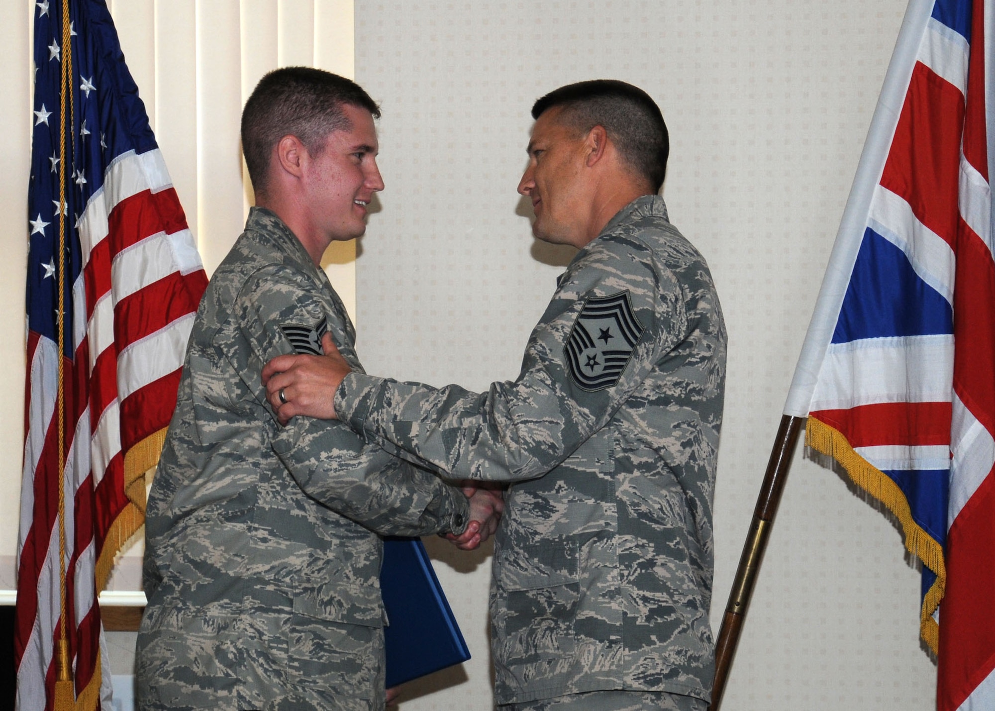From right, U.S. Air Force Chief Master Sgt. Tracy Jones, 100th Air Refueling Wing command chief, congratulates U.S. Air Force Master Sgt. Keith Skulimoski, 100th Civil Engineer Squadron Prime Base Engineer Emergency Force manager from Pemberton, N.J., following the presentation of his certificate of promotion Aug. 19, 2013, on RAF Mildenhall, England. Skulimoski was promoted under the stripes for exceptional performers program from the rank of technical sergeant to master sergeant. “Due to his leadership capability, unrelenting commitment to the Air Force core values, and solid volunteer ethic, Skulimoski has been chosen for the 2013 STEP Program and promoted to master sergeant,” Jones said. (U.S. Air Force photo by Gina Randall/Released)