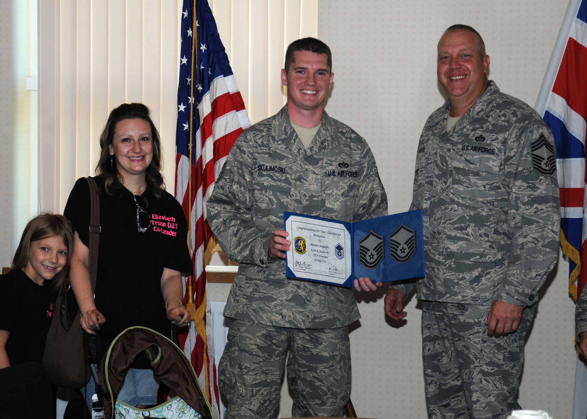 Right, U.S. Air Force Chief Master Sgt. John Gibson, 100th Civil Engineer Squadron superintendent, congratulates U.S. Air Force Master Sgt. Keith Skulimoski, 100th CES Prime Base Engineer Emergency Force manager from Pemberton, N.J., center, and Skulimoski’s family, left, Aug. 19, 2013, on RAF Mildenhall, England. Skulimoski was promoted under the stripes for exceptional performers program from the rank of technical sergeant to master sergeant. Each year, the Air Force releases a limited number (usually less than 200 across the Air Force), slots for a STEP promotion. (U.S. Air Force photo by Gina Randall/Released)