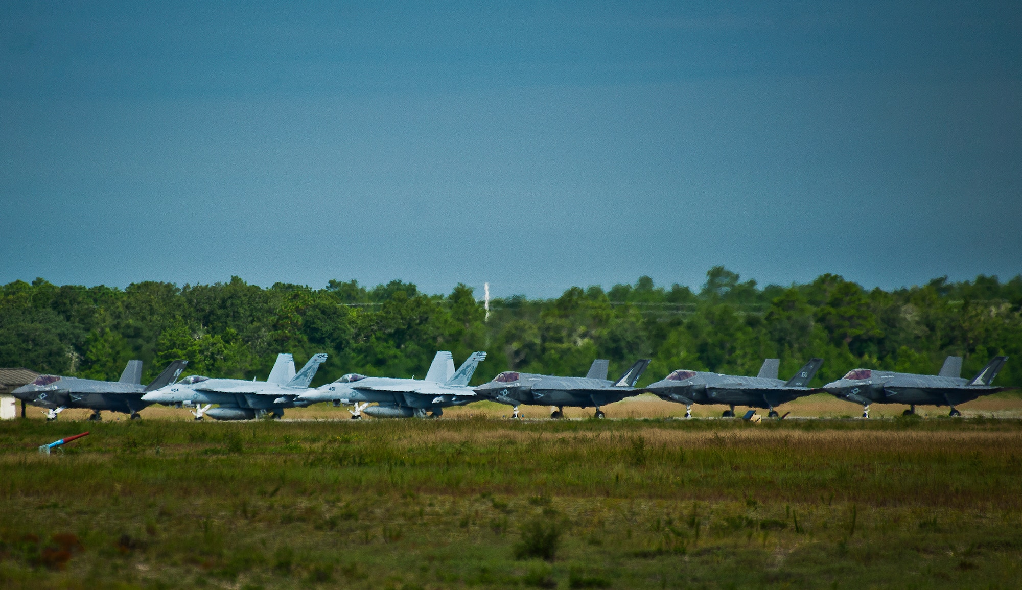 All three F-35 Lightning II variants along with two F/A-18 Hornets line up at the end of the runway prior to take off Aug. 14 at Eglin Air Force Base, Fla.  This was the first time all three had been in the air at the same time over Eglin.  To date, the Air Force, Marine Corps and the Navy have flown more than 2,000 sorties here.  (U.S. Air Force photo/Samuel King Jr.)