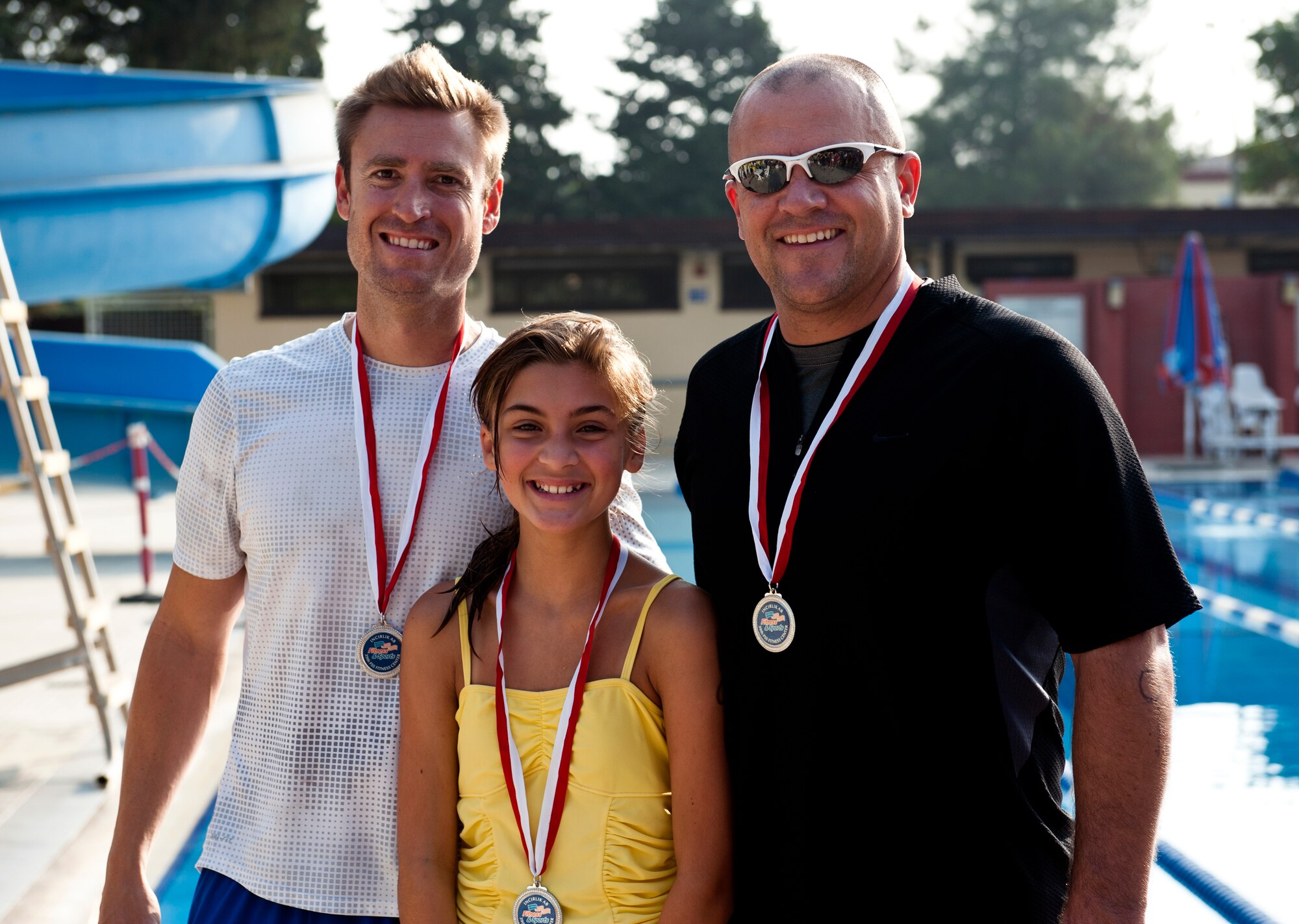 The second place team in the Incirlik sprint triathlon, Beau Robbins, Kyley Barnes and Trinity Barnes, show off their medals Aug. 17, 2013, at Incirlik Air Base, Turkey. A total of 10 teams competed in the triathlon. (U.S. Air Force photo by Senior Airman Daniel Phelps/Released)