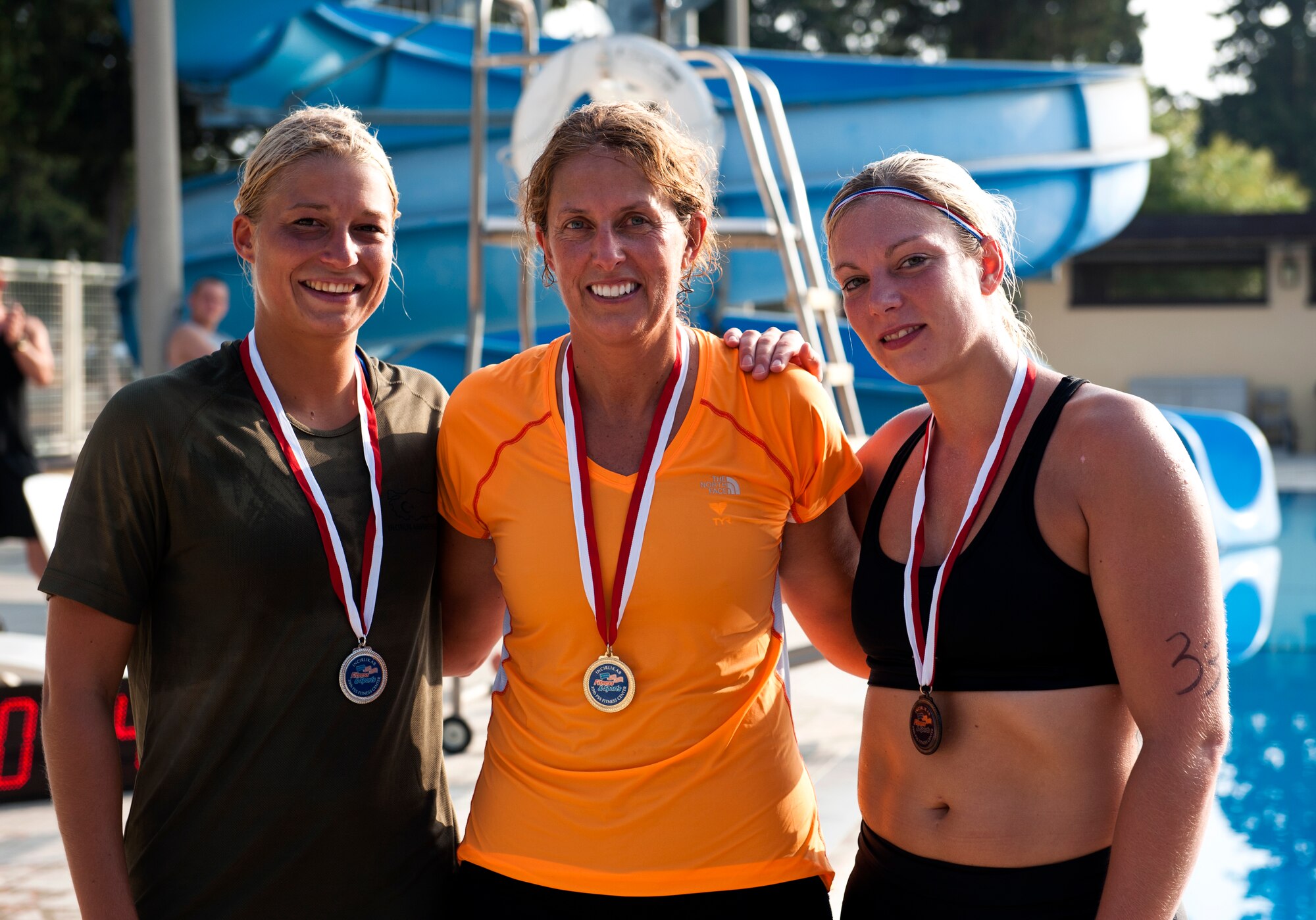 The top three female finishers of the Incirlik sprint triathlon, Lindsay Vande Pol (2nd), Julie Ostrand (1st) and Stephie Terwint (3rd); show off their medals Aug. 17, 2013, at Incirlik Air Base, Turkey. A total of 30 individuals competed in the triathlon. (U.S. Air Force photo by Senior Airman Daniel Phelps/Released)