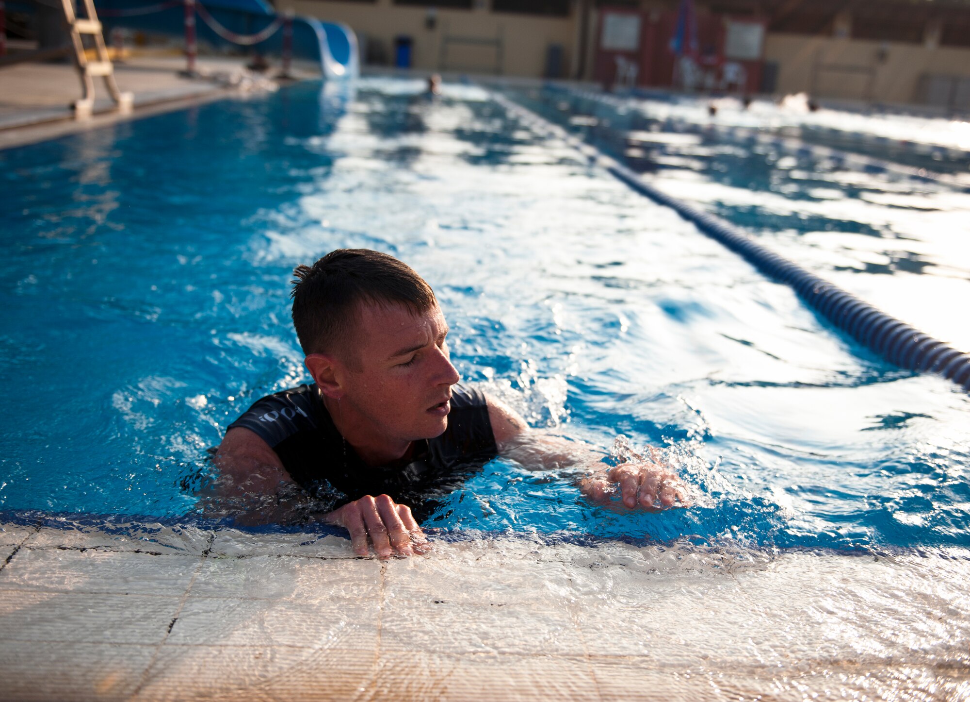 Robert Wilson rests on the side of the pool after finishing the Incirlik sprint triathlon Aug. 17, 2013, at Incirlik Air Base, Turkey. The athletes raced as either teams or individuals covering a 5K run, 20K bike ride and 200 meter swim. (U.S. Air Force photo by Senior Airman Daniel Phelps/Released)
