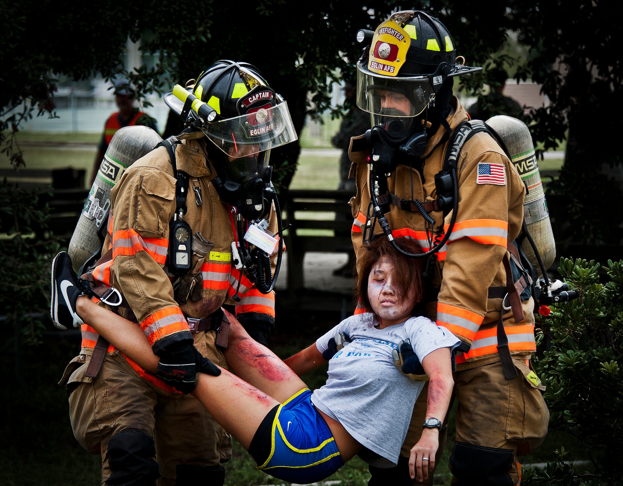 Senior Airman Paul Steele and Timothy Panzer, of the 96th Civil Engineer Squadron, carry an unconscious victim to safety after a simulated explosion during a radiological and force protection condition exercise Aug. 16 at Eglin Air Force Base, Fla.  First responders from security forces, the fire department and medical group arrived to secure the scene and help the simulated victims.  (U.S. Air Force photo/Samuel King Jr.)