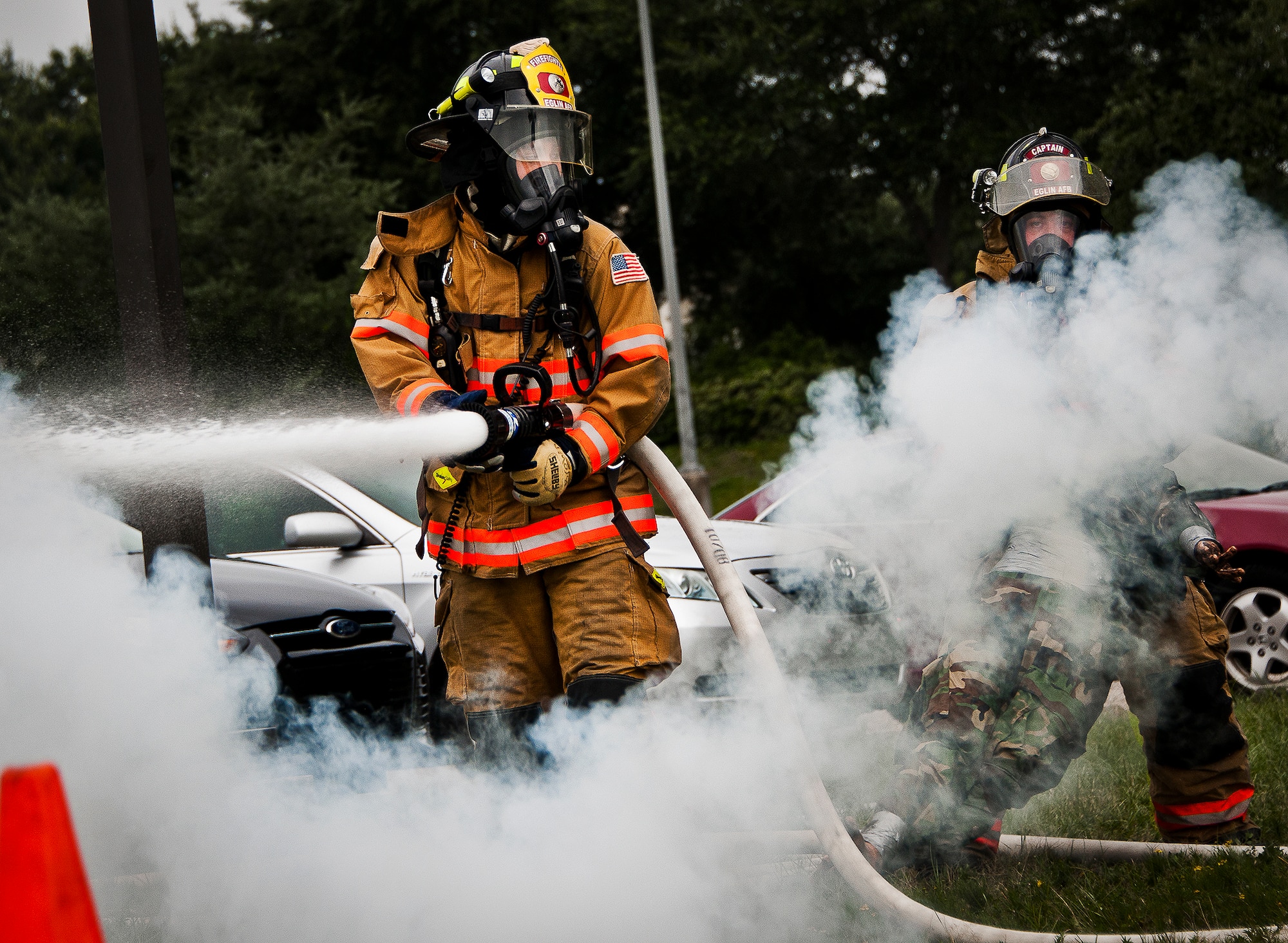 Senior Airman Paul Steele and Timothy Panzer, of the 96th Civil Engineer Squadron, spray down a fire caused by a simulated explosion during a radiological and force protection condition exercise Aug. 16 at Eglin Air Force Base, Fla.  First responders from security forces, the fire department and medical group arrived to secure the scene and help the simulated victims.  (U.S. Air Force photo/Samuel King Jr.)