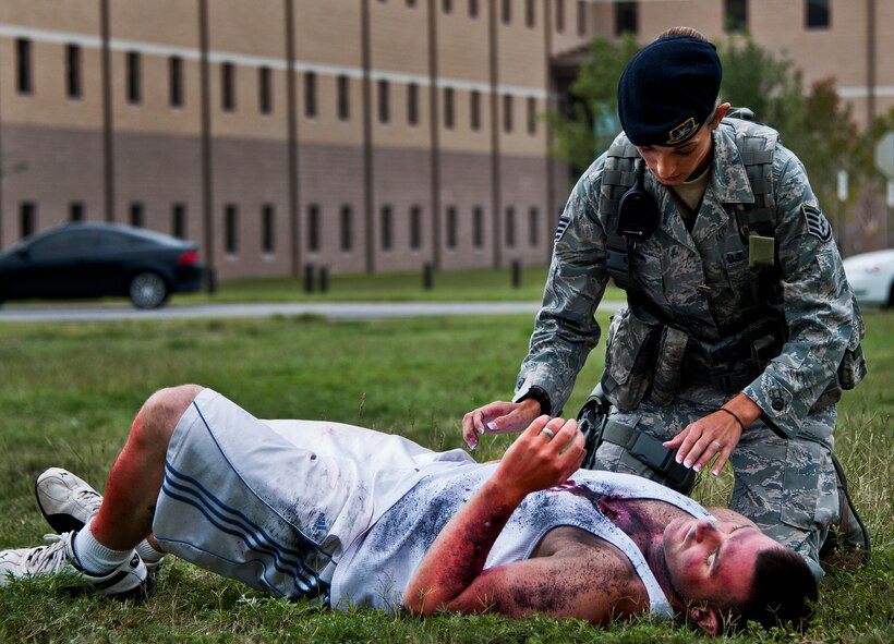 Staff Sgt. Jacqueline Lawson, of the 96th Security Forces Squadron, evaluates the injuries of a victim of a simulated explosion during a radiological and force protection condition exercise Aug. 16 at Eglin Air Force Base, Fla.  First responders from security forces, the fire department and medical group arrived to secure the scene and help the simulated victims.  (U.S. Air Force photo/Samuel King Jr.)