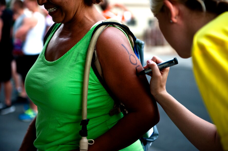 A fitness center member writes a competitor number on a triathlon participant Aug. 17, 2013, at Incirlik Air Base, Turkey. A total of 65 athletes competed in the Incirlik sprint triathlon. (U.S. Air Force photo by Senior Airman Daniel Phelps/Released)