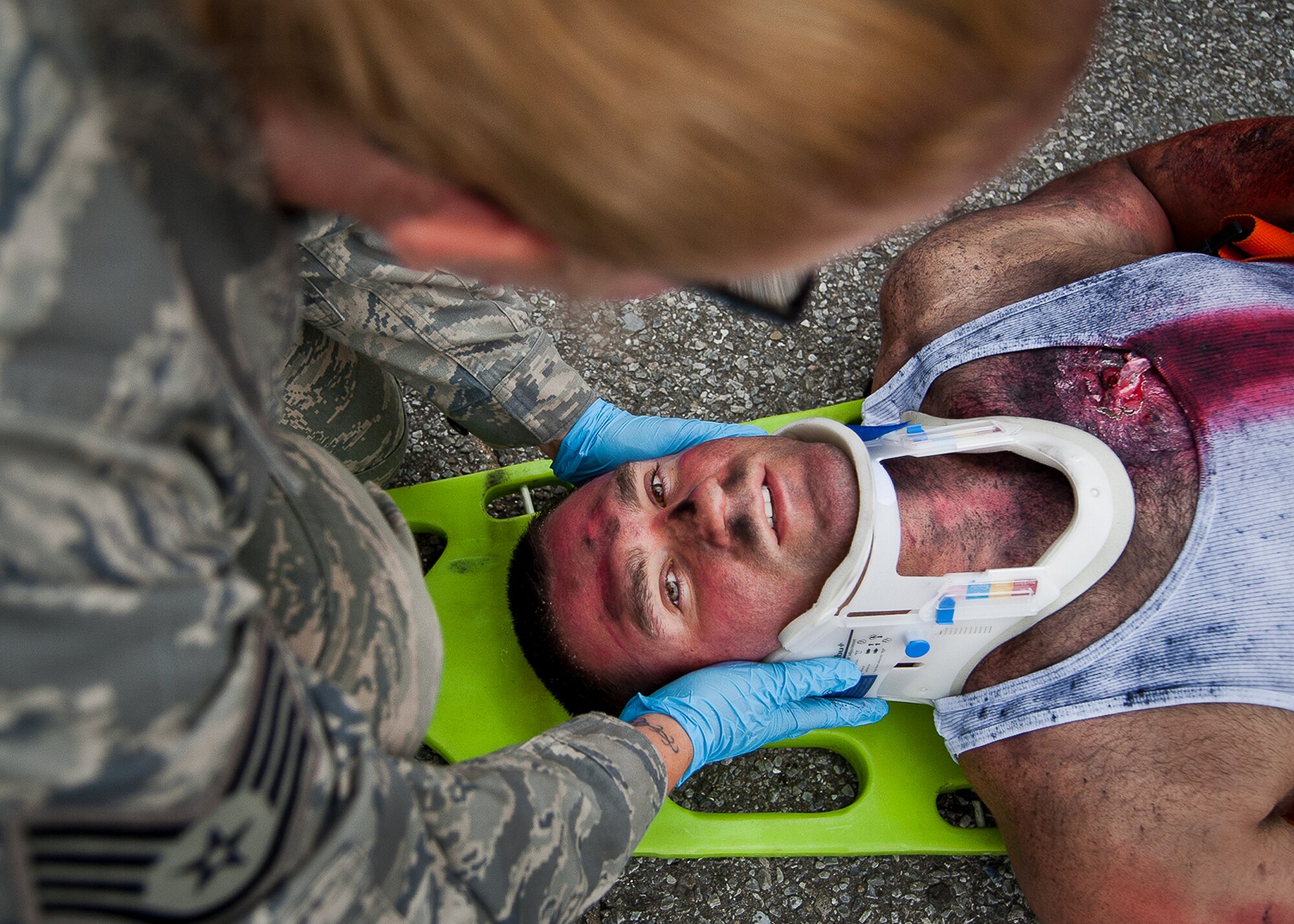 Staff Sgt. Jill Dowd, of the 96th Medical Group, secures a victim's neck after a simulated explosion during a radiological and force protection condition exercise Aug. 16 at Eglin Air Force Base, Fla.  First responders from security forces, the fire department and medical group arrived to secure the scene and help the simulated victims.  (U.S. Air Force photo/Samuel King Jr.)