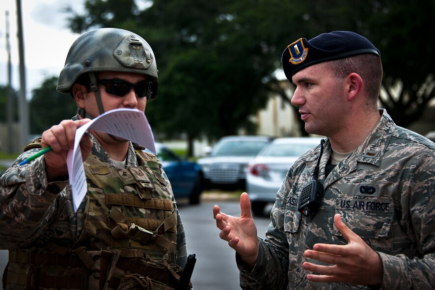 An explosive ordnance disposal Airman talks with 2nd Lt. Brandon Casso, of the 96th Security Forces Squadron, about where the detonation occurred after a simulated explosion during a radiological and force protection condition exercise Aug. 16 at Eglin Air Force Base, Fla.  First responders from security forces, the fire department and medical group arrived to secure the scene and help the simulated victims.  (U.S. Air Force photo/Samuel King Jr.)