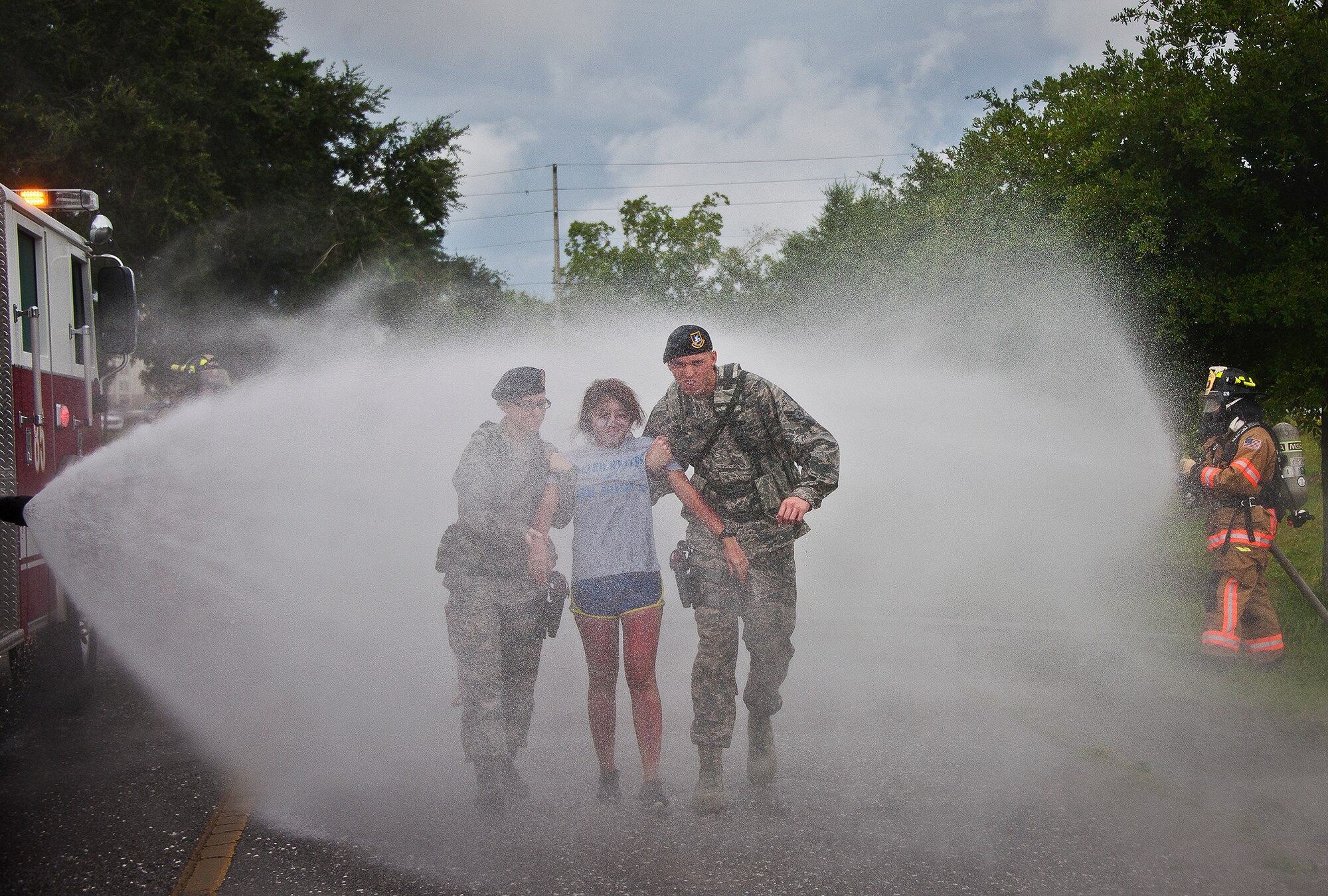 Security Forces personnel escort a victim through the decontamination rinse after they were exposed to a simulated explosion during a radiological and force protection condition exercise Aug. 16 at Eglin Air Force Base, Fla.  First responders from security forces, the fire department and medical group arrived to secure the scene and help the simulated victims.  (U.S. Air Force photo/Samuel King Jr.)