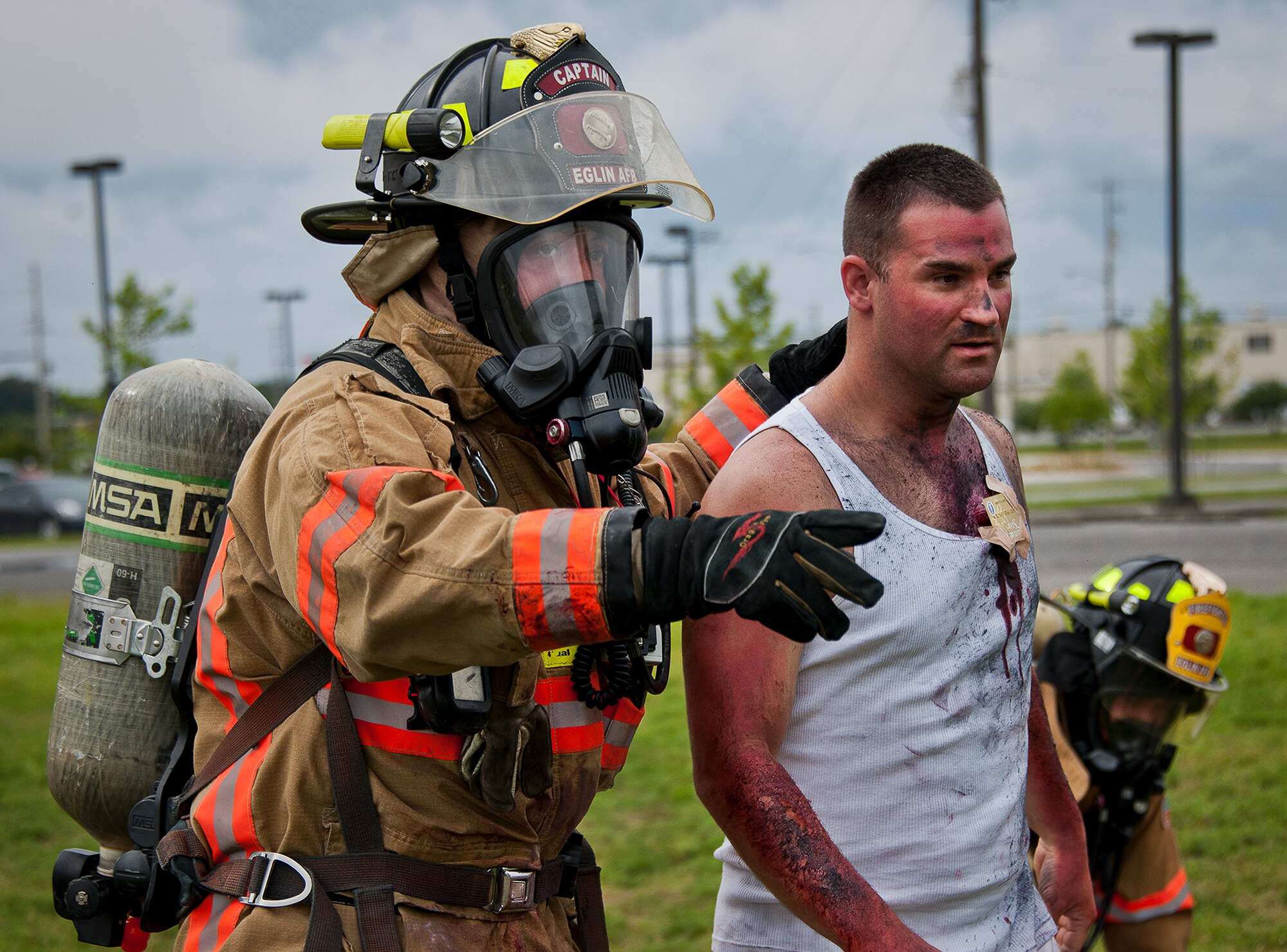 Timothy Panzer, of the 96th Civil Engineer Squadron, directs a victim to the decontamination area after a simulated explosion during a radiological and force protection condition exercise Aug. 16 at Eglin Air Force Base, Fla.  First responders from security forces, the fire department and medical group arrived to secure the scene and help the simulated victims.  (U.S. Air Force photo/Samuel King Jr.)