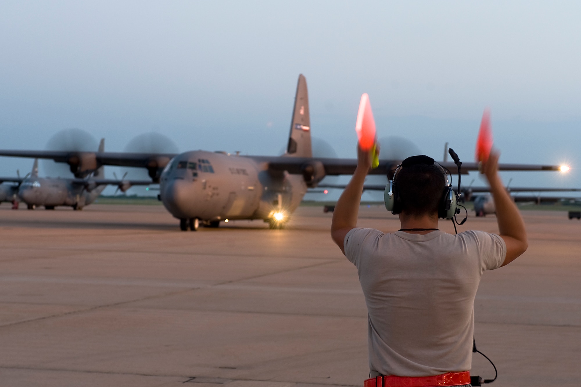 U.S. Air Force Airman 1st Class John Aguilar Porrata-Doria, 317th Aircraft Maintenance Squadron crew chief, marshals a C-130J Aug. 10, 2013, at Dyess Air Force Base, Texas. 317th Airlift Group C-130Js, aircrews and maintainers recently departed from Dyess Air Force Base, to support U.S. Africa Command at Ramstein Air Base, Germany. (U.S. Air Force photo by Airman 1st Class Peter Thompson/Released)
