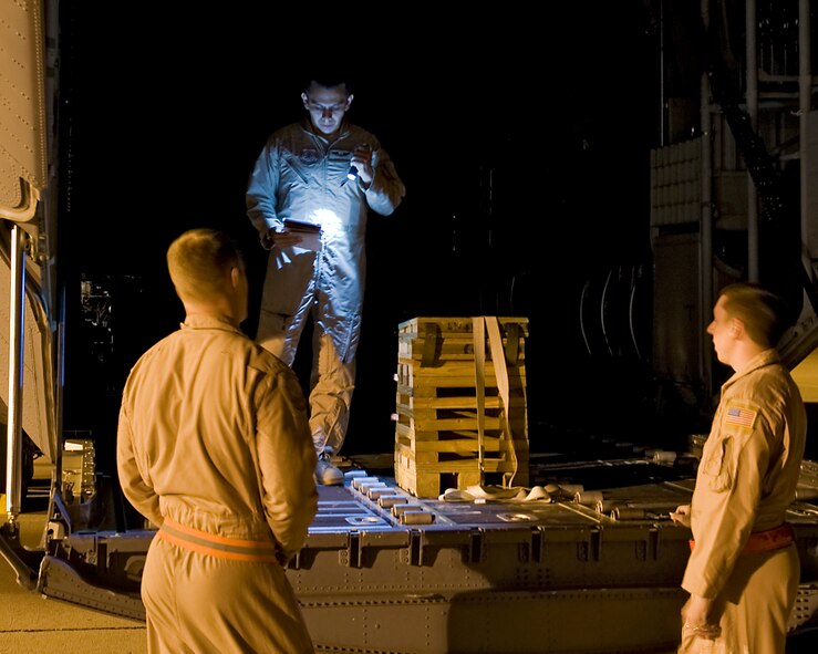 U.S. Air Force Senior Airman Ramon Granados, 39th Airlift Squadron loadmaster, center, looks over an aircraft checklist Aug. 10, 2013, at Dyess Air Force Base, Texas. 317th Airlift Group C-130Js, aircrews and maintainers recently departed from Dyess Air Force Base, to support U.S. Africa Command at Ramstein Air Base, Germany. (U.S. Air Force photo by Airman 1st Class Peter Thompson/Released)