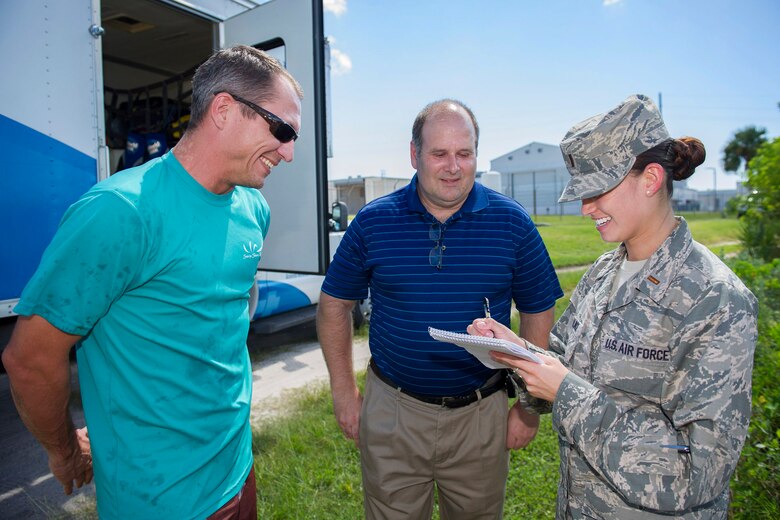 Zach Johnson, research assistant for the Sea-to-Shore alliance, tells Mr. Michael Blaylock, chief of natural assets, 45th Civil Engineer Squadron, and 2nd Lt. Alicia Wallace, 45th Space Wing public affairs officer, about the tracking sensor attached to the rehabilitated manatee at Cape Canaveral Air Force Station, Fla., Aug 13. (U.S. Air Force Photo/Matthew Jurgens)