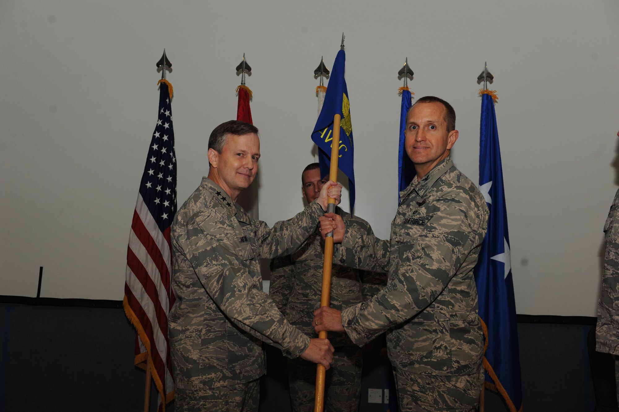 U.S. Air Force Lt. Gen. John Hesterman III, U.S. Air Forces Central Command commander, left, passes the Air Warfare Center guide-on to U.S. Air Force Col. Andrew R. Brabson, AFCENT AWC commander, during a ceremony, undisclosed location, Southwest Asia, August 14. (U.S. Air Force photo by Staff Sgt. Joshua J. Garcia)