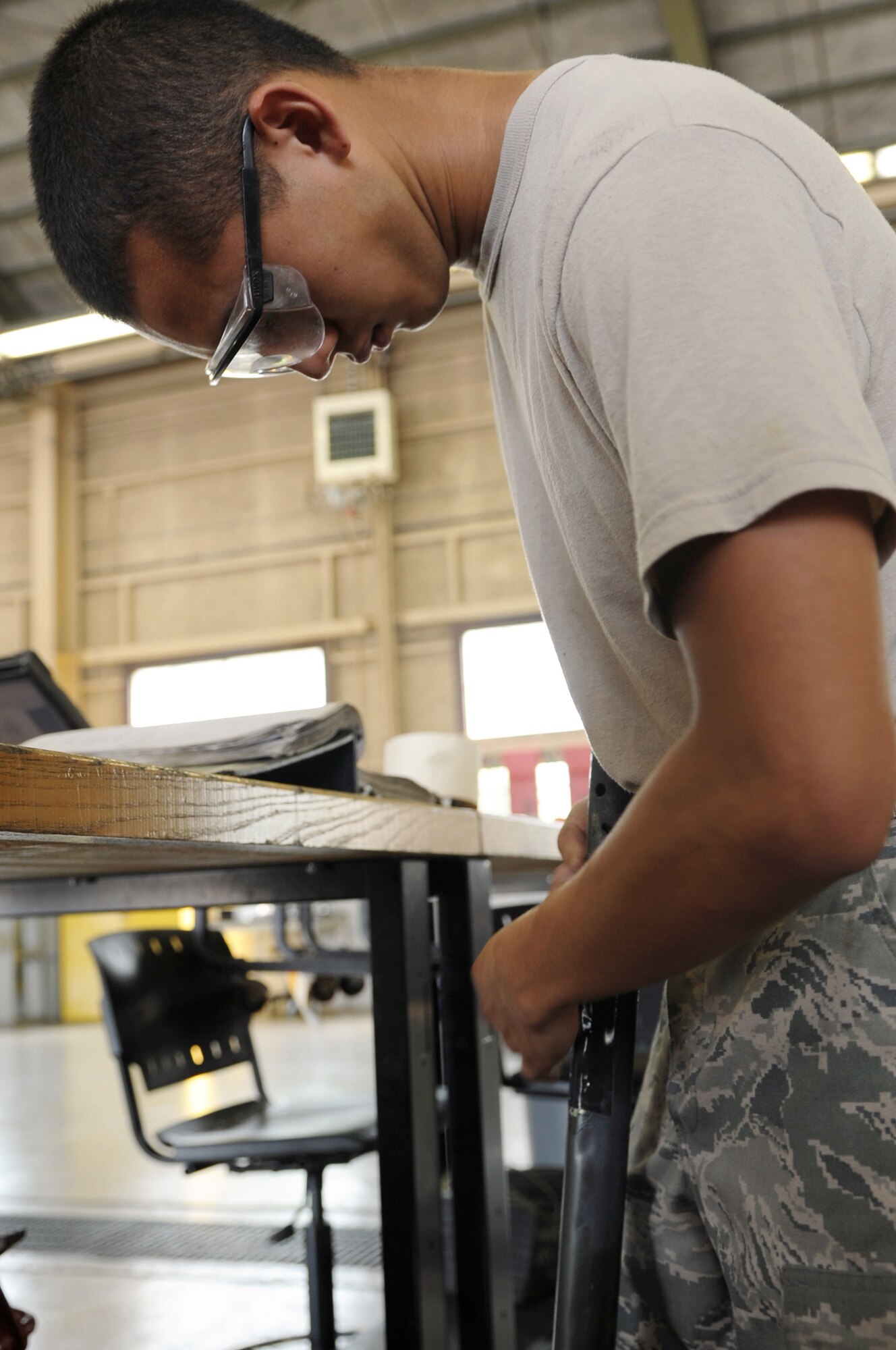 YOKOTA AIR BASE, Japan -- Airman 1st Class George Rivas affixes new tape to a B-4 stand armrail Aug. 14, 2013, at Yokota Air Base, Japan. Rivas is a Airmen in the 374th Maintenance Squadron Aerospace Ground Equipment flight. (U.S. Air Force photo by Senior Airman Desiree Economides)