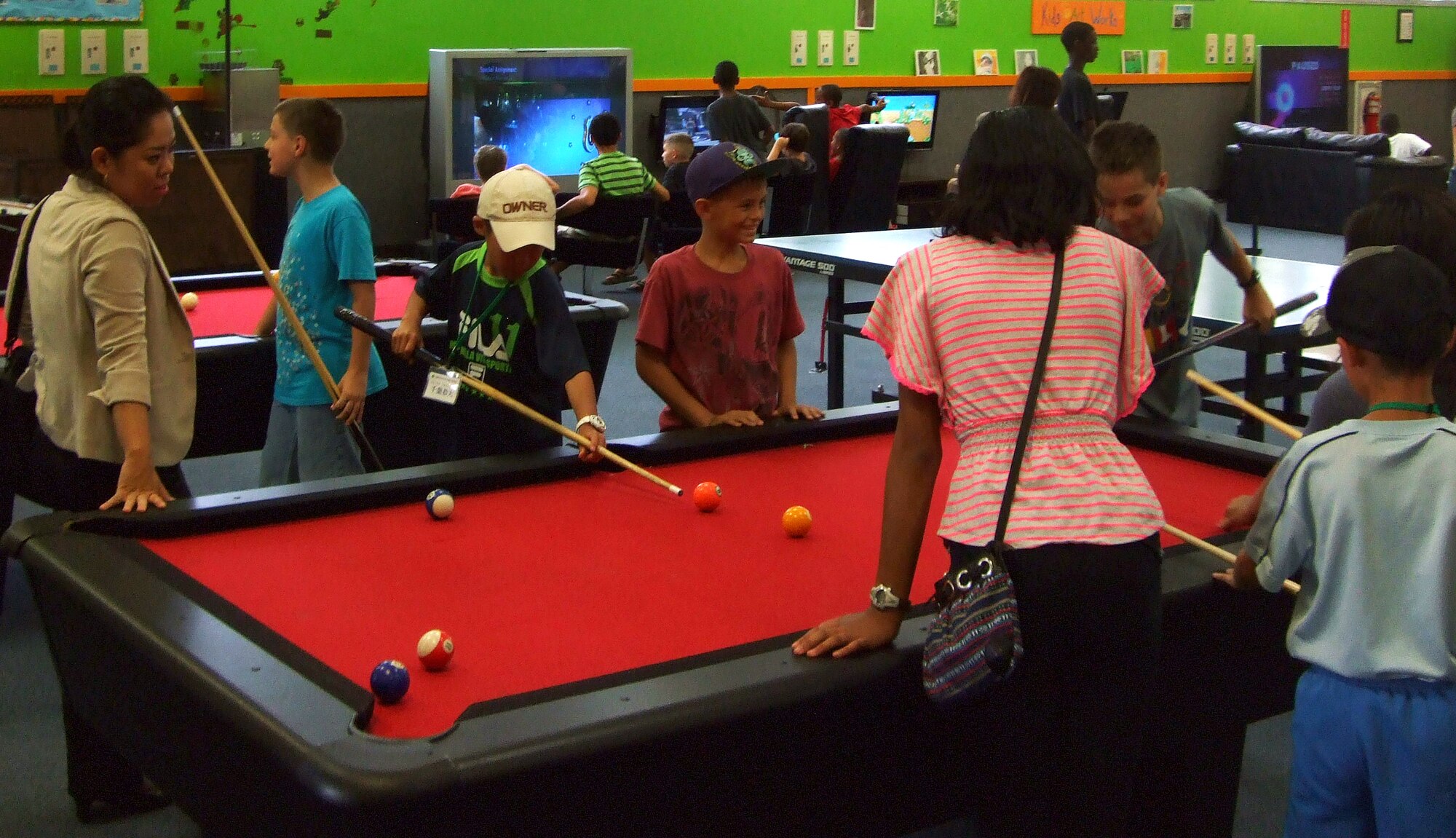 Japanese primary school children from Nagano Achi village play pool with American military children at the youth center during a visit on Kadena Air Base, Japan, Aug. 5, 2013. The children spent time playing video games, dodgeball and pool with the military children. (Courtesy photo)