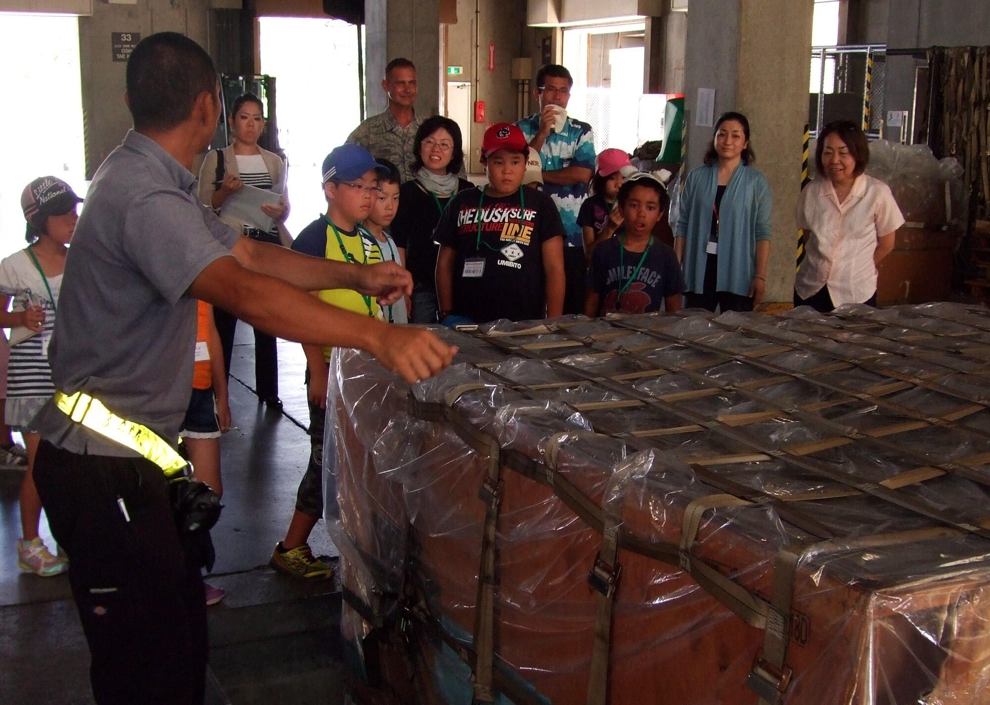 Japanese primary school children from Nagano Achi village view cargo during a visit to the 733rd Air Mobility Squadron air cargo and terminal on Kadena Air Base, Japan, Aug. 5, 2013. During this visit the children had the opportunity to visit several 733rd AMS units. (Courtesy photo)