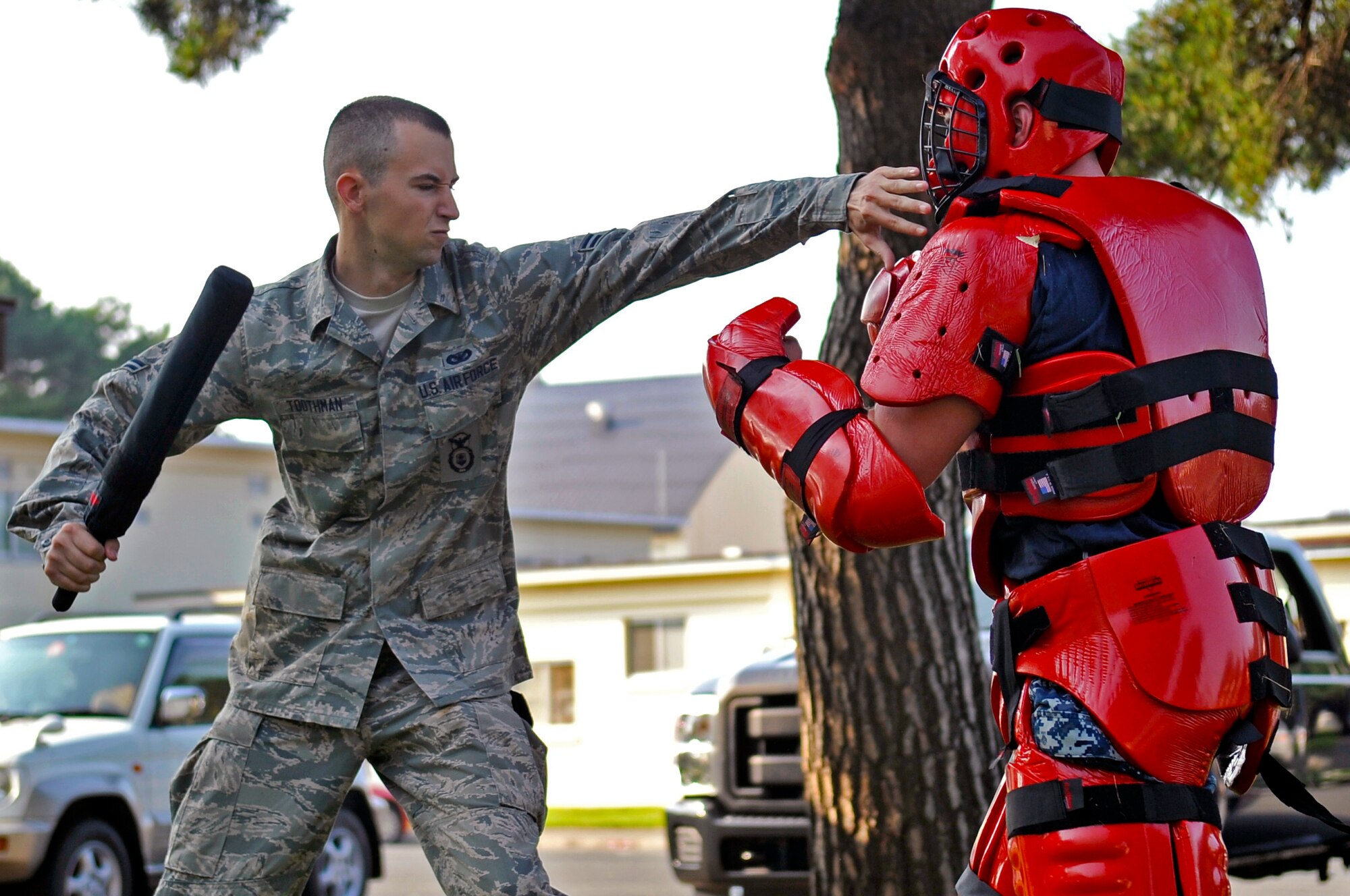 U.S. Air Force Airman 1st Class David Toothman, 35th Security Forces Squadron basic force protector, uses his training baton to strike a simulated enemy combatant during Fly Away Security Team training at Misawa Air Base, Japan, Aug. 15, 2013. During this training, Airmen learned verbal judo. This oral engagement method taught 35 SFS personnel how to deter a situation before using force. (U.S. Air Force photo by Airman 1st Class Zachary Kee)