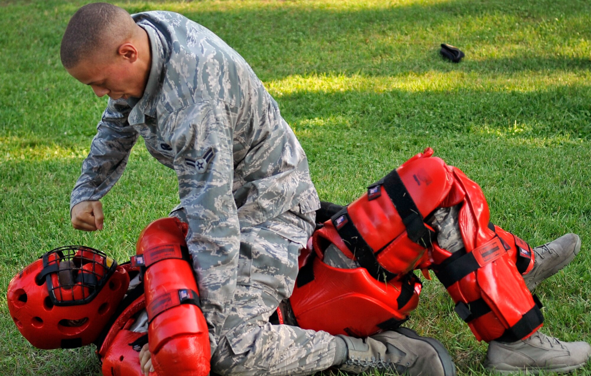 U.S. Air Force Airman 1st Class Nicholas Kelly, 35th Security Forces Squadron basic force protector, uses a ground and pound strategy on Staff Sgt. LaseDerick McDougle, 35 SFS team chief and red man volunteer, during Fly Away Security Team training at Misawa Air Base, Japan, Aug. 15, 2013. FAST training is used to prepare 35 SFS Airmen for posting security for aircraft on an unsecured airfield. (U.S. Air Force photo by Airman 1st Class Zachary Kee)