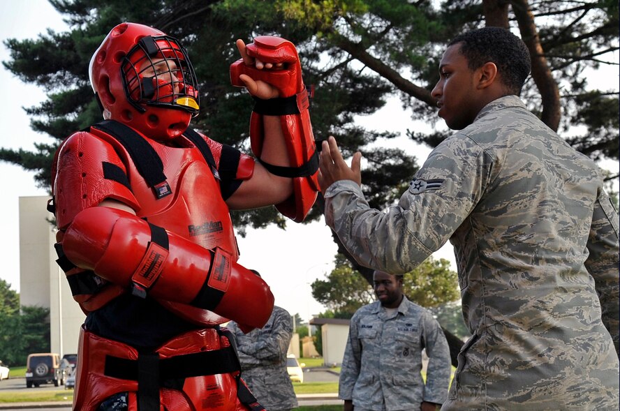 U.S. Air Force Airman 1st Class Malik Henriques, 35th Security Forces Squadron basic force protector, engages Master at Arms 2nd Class Alexander Knapp, red man volunteer, as he simulates an enemy combatant during Fly Away Security Team training at Misawa Air Base, Japan, Aug. 15, 2013. During the training, members of the 35 SFS learned to use verbal judo. Verbal judo is an oral method used to resolve altercations without the use of force. (U.S. Air Force photo by Airman 1st Class Zachary Kee) 