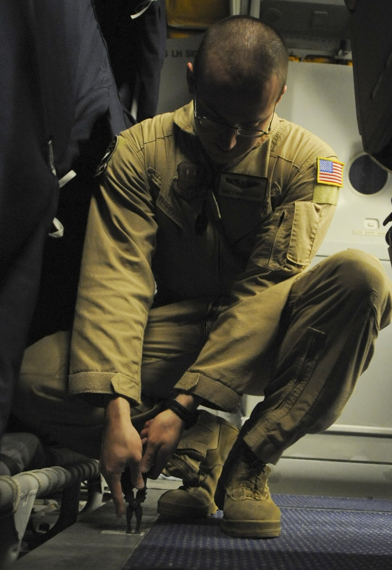 U.S. Air Force Senior Airman Turner Foote, 908th Expeditionary Air Refueling Squadron boom operator, uses a multi-tool to tighten a bolt holding the floor down in the passenger area of a KC-10 Extender at an undisclosed location in Southwest Asia Aug. 10, 2013. Foote is one of four crew members typically operating an Extender, which is an Air Mobility Command advanced tanker and cargo aircraft designed to provide increased global mobility for U.S. armed forces. Turner calls Jackson, Miss., home and is deployed from Joint Base McGuire-Dix-Lakehurst, N.J. (U.S. Air Force photo by Staff Sgt. Jacob Morgan)