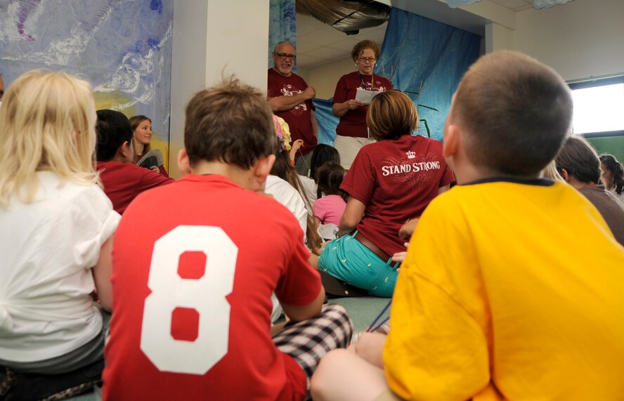 Dave and Beth Kanelos, 35th Fighter Wing Chapel Vacation Bible School volunteers, speak to children attending VBS at Misawa Air Base, Japan, Aug 16, 2013. Children went through many areas that the chapel had setup throughout the week where they learned to “Stand Strong” throughout life.(U.S. Air Force photo by Airman 1st Class Kaleb Snay)