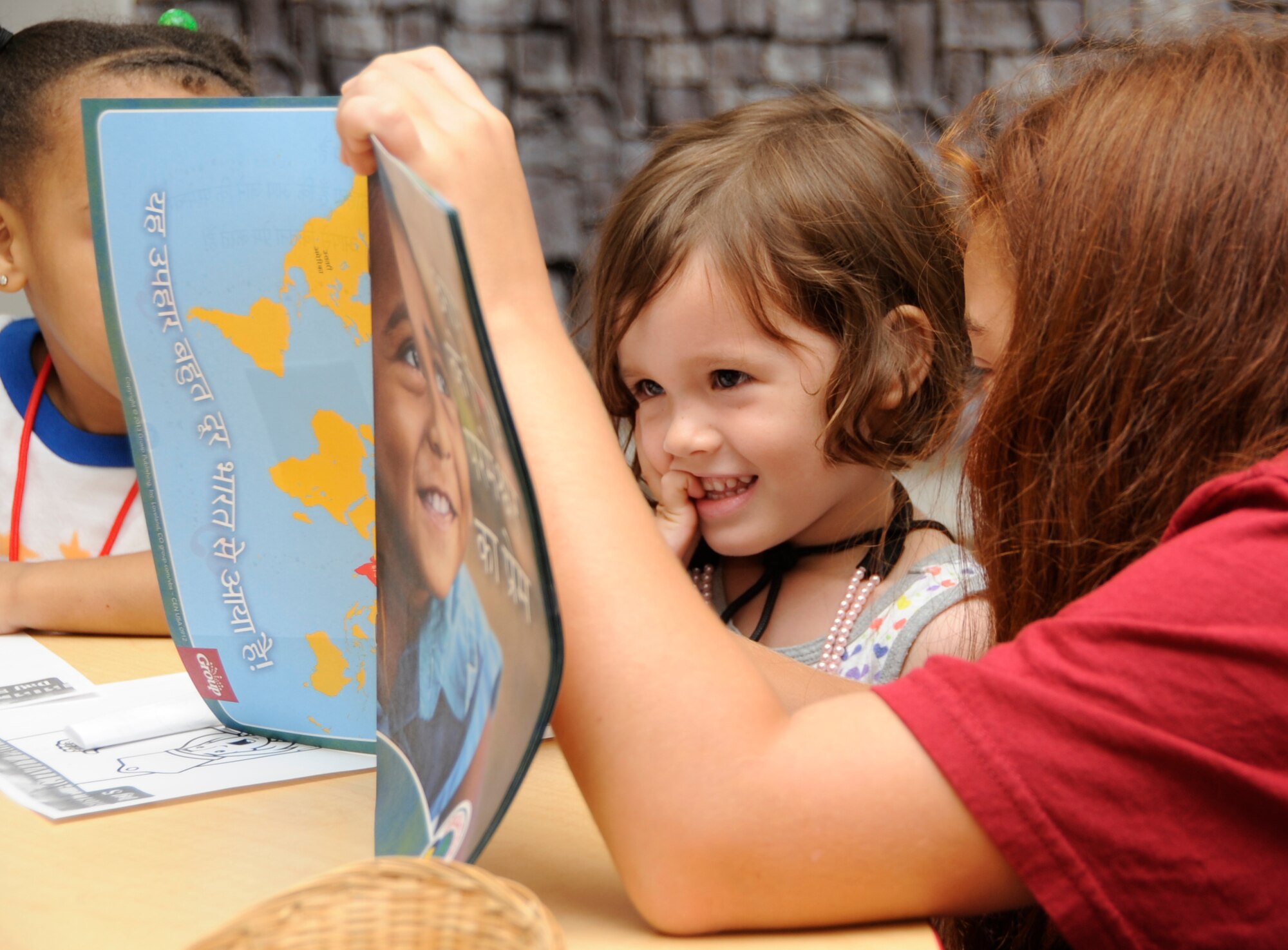 Adriana Serrano, 35th Fighter Wing Chapel Vacation Bible School volunteer, reads a book to a child attending VBS at Misawa Air Base, Japan, Aug 16, 2013. The chapel’s VBS came to a close with an average attendance of 200 children per day for five days. (U.S. Air Force photo by Airman 1st Class Kaleb Snay)