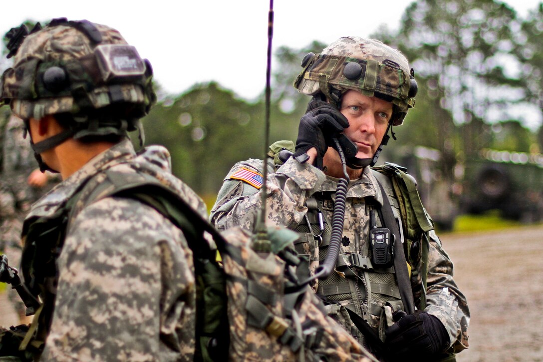 Army Lt. Col. Thomas Hallowell, right, communicates with his soldiers by radio during a field training exercise on Fort Pickett, Va., Aug. 18, 2013. Hallowell is the commander of the New Jersey Army National Guard's 1st Battalion, 114th Infantry Regiment, 50th Infantry Brigade Combat Team.